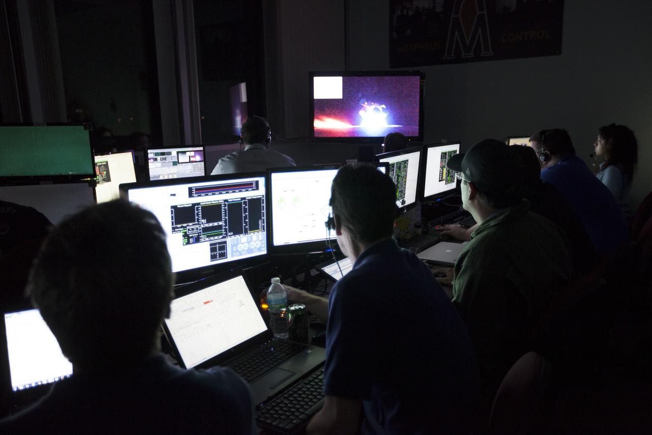 CAPE CANAVERAL, Fla. -- Engineers in the Morpheus Control Room monitor NASA's Project Morpheus prototype lander as it lifts off on the first free flight test at night from a launch pad at the north end of the Shuttle Landing Facility at NASA's Kennedy Space Center in Florida. The 98-second test began at 10:02 p.m. EDT with the Morpheus lander launching from the ground over a flame trench and ascending more than 800 feet. The vehicle, with its autonomous landing and hazard avoidance technology, or ALHAT sensors, surveyed the hazard field to determine safe landing sites. Morpheus then flew forward and downward covering approximately 1,300 feet while performing a 78-foot divert to simulate a hazard avoidance maneuver. The lander then descended and landed on a dedicated pad inside the test field. Project Morpheus tests NASA’s ALHAT and an engine that runs on liquid oxygen and methane, which are green propellants. These new capabilities could be used in future efforts to deliver cargo to planetary surfaces.    The landing facility provides the lander with the kind of field necessary for realistic testing, complete with rocks, craters and hazards to avoid. Morpheus’ ALHAT payload allows it to navigate to clear landing sites amidst rocks, craters and other hazards during its descent. Project Morpheus is being managed under the Advanced Exploration Systems, or AES, Division in NASA’s Human Exploration and Operations Mission Directorate. The efforts in AES pioneer new approaches for rapidly developing prototype systems, demonstrating key capabilities and validating operational concepts for future human missions beyond Earth orbit. For more information on Project Morpheus, visit http://morpheuslander.jsc.nasa.gov/.  Photo credit: NASA/Kim Shiflett