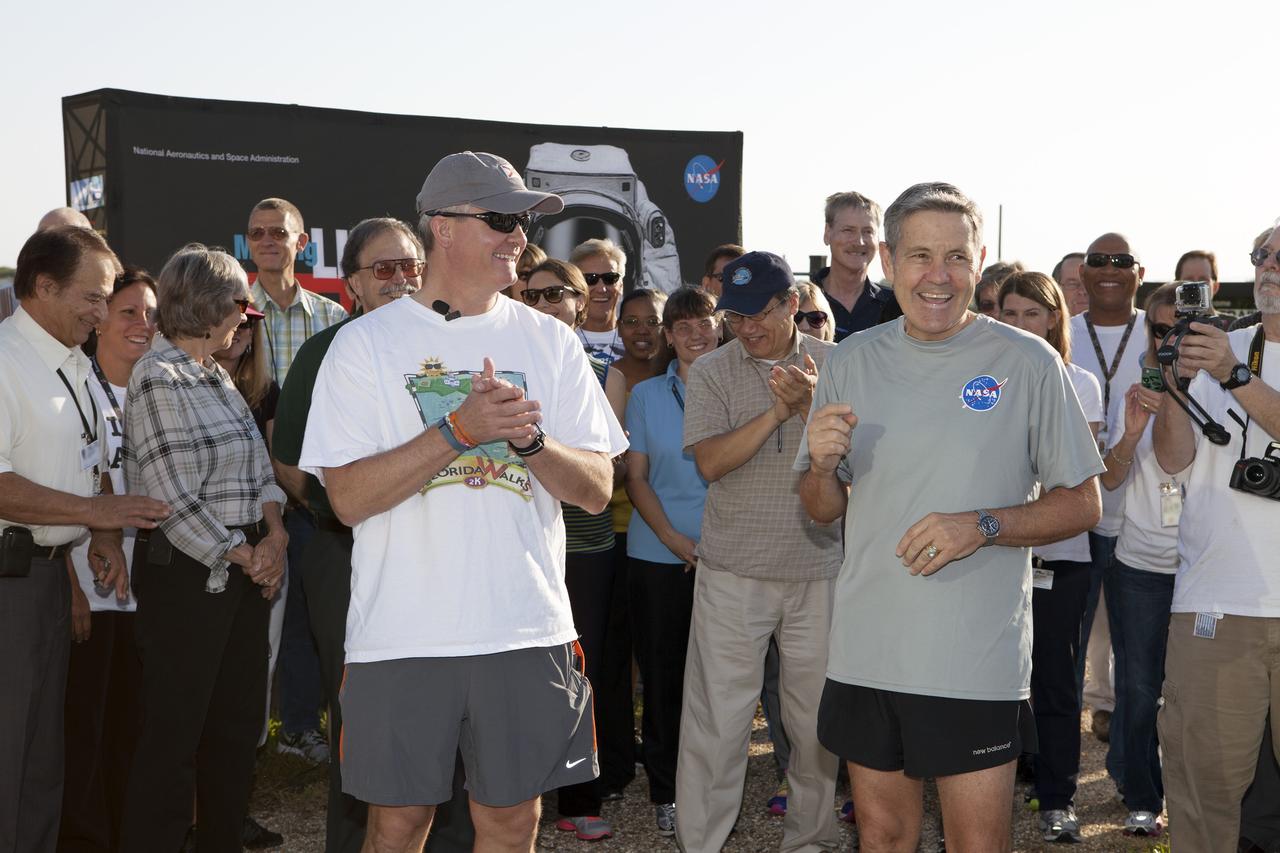 CAPE CANAVERAL, Fla. – Kennedy Space Center Director Bob Cabana, right, Florida State Surgeon General John Armstrong and other guests prepare for an early morning run at the center's Pathfinder Trail near the Operations and Support Building II at Kennedy Space Center in Florida, to officially kick off National Employee Health and Fitness Month with the NASA Moves! challenge.    NASA Moves! challenged the workforce from each of the agency's field centers to engage in at least 20 minutes of activity, or 10,000 steps, each day from May 18-31. About 100 people participated in the kickoff event on the Pathfinder Trail in the heart of the center's Launch Complex 39. The one-third-mile-long gravel walkway traces the iconic shape of a space shuttle orbiter and features a set of exercise stations. The friendly contest is part of NASA's new Health4Life initiative, a Web-based health initiative designed to help employees track their health, fitness and nutrition. Health4Life also provides an array of resources geared toward increasing physical activity. Photo credit: NASA/Dimitri Gerondidakis