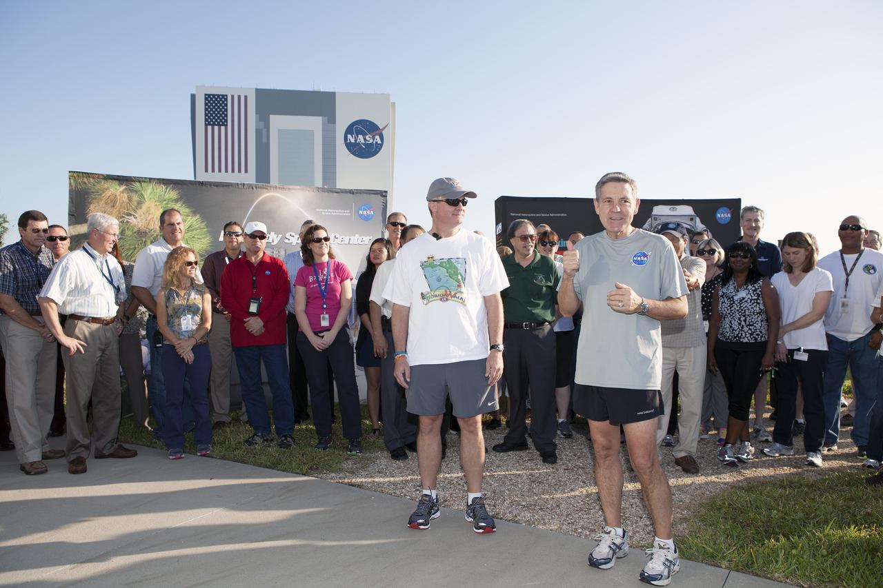 CAPE CANAVERAL, Fla. – Kennedy Space Center Director Bob Cabana, right, Florida State Surgeon General John Armstrong, other Kennedy managers and guests prepare for an early morning run at the center's Pathfinder Trail near the Operations and Support Building II at Kennedy Space Center in Florida, to officially kick off National Employee Health and Fitness Month with the NASA Moves! challenge.    NASA Moves! challenged the workforce from each of the agency's field centers to engage in at least 20 minutes of activity, or 10,000 steps, each day from May 18-31. About 100 people participated in the kickoff event on the Pathfinder Trail in the heart of the center's Launch Complex 39. The one-third-mile-long gravel walkway traces the iconic shape of a space shuttle orbiter and features a set of exercise stations. The friendly contest is part of NASA's new Health4Life initiative, a Web-based health initiative designed to help employees track their health, fitness and nutrition. Health4Life also provides an array of resources geared toward increasing physical activity. Photo credit: NASA/Dimitri Gerondidakis