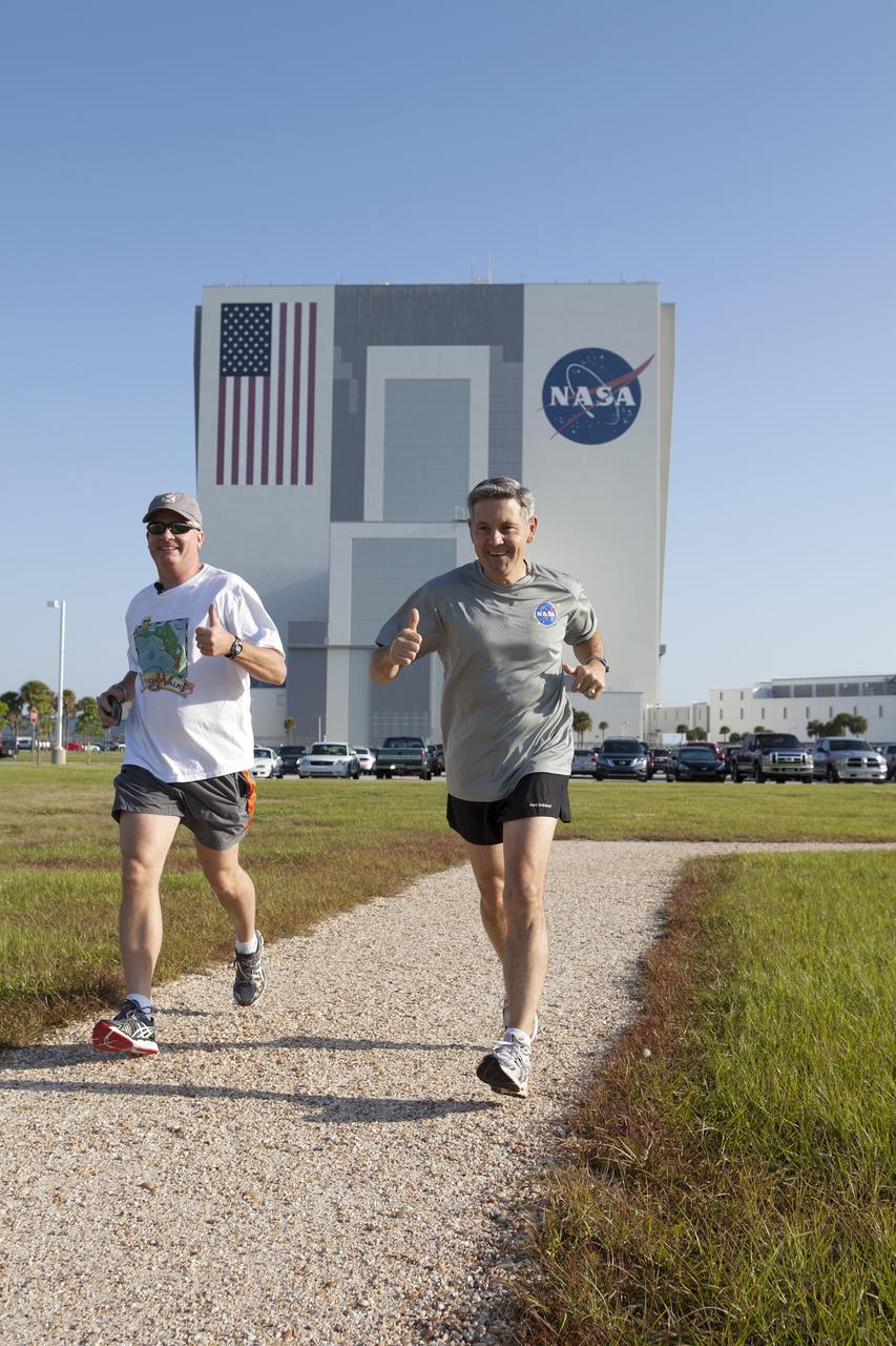 CAPE CANAVERAL, Fla. – Kennedy Space Center Director Bob Cabana, right, and Florida State Surgeon General John Armstrong take an early morning run along the center's Pathfinder Trail near the Operations and Support Building II at Kennedy Space Center in Florida, to officially kick off National Employee Health and Fitness Month with the NASA Moves! challenge.    NASA Moves! challenged the workforce from each of the agency's field centers to engage in at least 20 minutes of activity, or 10,000 steps, each day from May 18-31. About 100 people participated in the kickoff event on the Pathfinder Trail in the heart of the center's Launch Complex 39. The one-third-mile-long gravel walkway traces the iconic shape of a space shuttle orbiter and features a set of exercise stations. The friendly contest is part of NASA's new Health4Life initiative, a Web-based health initiative designed to help employees track their health, fitness and nutrition. Health4Life also provides an array of resources geared toward increasing physical activity. Photo credit: NASA/Dimitri Gerondidakis