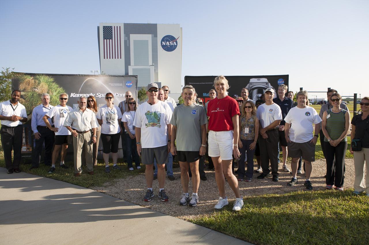 CAPE CANAVERAL, Fla. – From left, Florida State Surgeon General John Armstrong, Kennedy Space Center Director Bob Cabana, Center Operations Director Nancy Bray and Kennedy workers and guests prepare to take an early morning run along the center's Pathfinder Trail near the Operations and Support Building II at Kennedy Space Center in Florida, to officially kick off National Employee Health and Fitness Month with the NASA Moves! challenge.    NASA Moves! challenged the workforce from each of the agency's field centers to engage in at least 20 minutes of activity, or 10,000 steps, each day from May 18-31. About 100 people participated in the kickoff event on the Pathfinder Trail in the heart of the center's Launch Complex 39. The one-third-mile-long gravel walkway traces the iconic shape of a space shuttle orbiter and features a set of exercise stations. The friendly contest is part of NASA's new Health4Life initiative, a Web-based health initiative designed to help employees track their health, fitness and nutrition. Health4Life also provides an array of resources geared toward increasing physical activity. Photo credit: NASA/Dimitri Gerondidakis