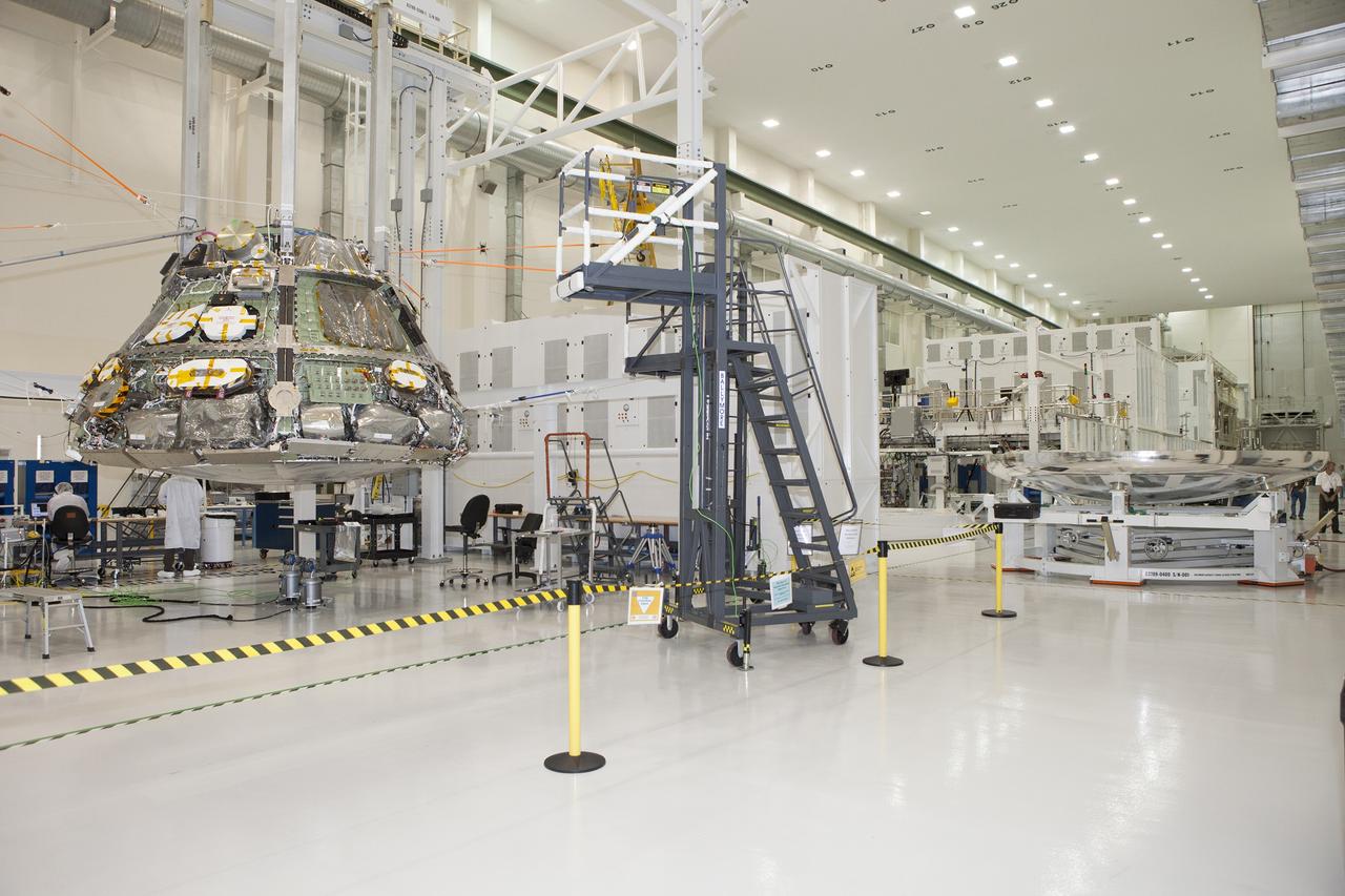 CAPE CANAVERAL, Fla. -- Inside the Operations and Checkout Building high bay at NASA's Kennedy Space Center in Florida, Lockheed Martin technicians and engineers have positioned the heat shield near the Orion crew module. Technicians have installed more than 200 instrumentation sensors on the heat shield and are preparing it for installation.    Orion is the exploration spacecraft designed to carry astronauts to destinations not yet explored by humans, including an asteroid and Mars. It will have emergency abort capability, sustain the crew during space travel and provide safe re-entry from deep space return velocities. The first unpiloted test flight of the Orion is scheduled to launch later this year atop a Delta IV rocket from Cape Canaveral Air Force Station in Florida to an altitude of 3,600 miles above the Earth's surface. The two-orbit, four-hour flight test will help engineers evaluate the systems critical to crew safety including the heat shield, parachute system and launch abort system. For more information, visit http://www.nasa.gov/orion. Photo credit: NASA/Daniel Casper