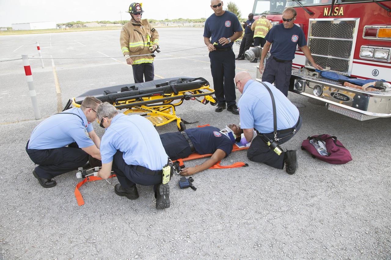 CAPE CANAVERAL, Fla. -- At NASA's Kennedy Space Center in Florida, a Fire Rescue team member serves as a "volunteer patient" for a simulated emergency operation. Paramedics are attaching a neck brace and leg splint. The activity taking place in Kennedy's Launch Complex 39 turn-basin parking lot was only one of several drills. It was part of a new training program that was developed by Kennedy's Fire Rescue department along with NASA Aircraft Operations to sharpen the skills needed to help rescue personnel learn how to collaborate with helicopter pilots in taking injured patients to hospitals as quickly as possible. Photo credit: NASA/Dan Casper