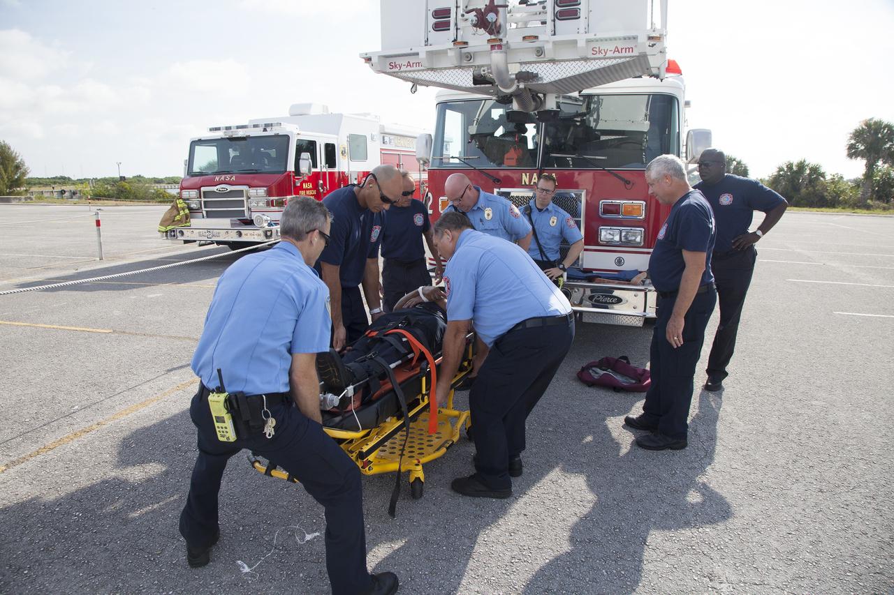 CAPE CANAVERAL, Fla. -- At NASA's Kennedy Space Center in Florida, a Fire Rescue team member serves as a "volunteer patient" for a simulated emergency operation. Paramedics prepare to move his stretcher to an awaiting helicopter. The activity taking place in Kennedy's Launch Complex 39 turn-basin parking lot was only one of several drills. It was part of a new training program that was developed by Kennedy's Fire Rescue department along with NASA Aircraft Operations to sharpen the skills needed to help rescue personnel learn how to collaborate with helicopter pilots in taking injured patients to hospitals as quickly as possible. Photo credit: NASA/Dan Casper