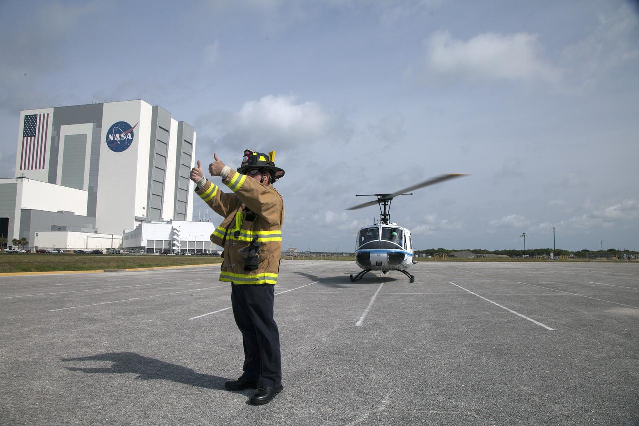 CAPE CANAVERAL, Fla. -- At NASA's Kennedy Space Center in Florida, an agency Fire Rescue team member gives "thumbs up" signaling that it is safe to bring in a stretcher with a "volunteer patient" to be placed aboard the nearby helicopter. The activity taking place in Kennedy's Launch Complex 39 turn-basin parking lot was only one of several drills. It was part of a new training program that was developed by Kennedy's Fire Rescue department along with NASA Aircraft Operations to sharpen the skills needed to help rescue personnel learn how to collaborate with helicopter pilots in taking injured patients to hospitals as quickly as possible. Photo credit: NASA/Dan Casper