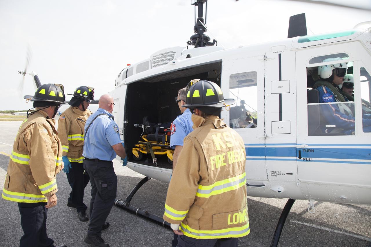 CAPE CANAVERAL, Fla. -- At NASA's Kennedy Space Center in Florida, a "volunteer patient" is carefully placed aboard a NASA helicopter as part of a training exercise. In an actual emergency, the pilots could fly an injured person from Kennedy to a nearby trauma center in minutes. The activity taking place in Kennedy's Launch Complex 39 turn-basin parking lot was only one of several drills. It was part of a new training program that was developed by Kennedy's Fire Rescue department along with NASA Aircraft Operations to sharpen the skills needed to help rescue personnel learn how to collaborate with helicopter pilots in taking injured patients to hospitals as quickly as possible. Photo credit: NASA/Dan Casper