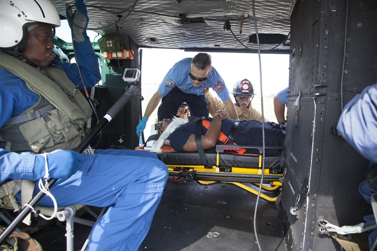 CAPE CANAVERAL, Fla. -- At NASA's Kennedy Space Center in Florida, a "volunteer patient" is carefully placed aboard a NASA helicopter as part of a training exercise. In an actual emergency, the pilots could fly an injured person from Kennedy to a nearby trauma center in minutes. The activity taking place in Kennedy's Launch Complex 39 turn-basin parking lot was only one of several drills. It was part of a new training program that was developed by Kennedy's Fire Rescue department along with NASA Aircraft Operations to sharpen the skills needed to help rescue personnel learn how to collaborate with helicopter pilots in taking injured patients to hospitals as quickly as possible. Photo credit: NASA/Dan Casper