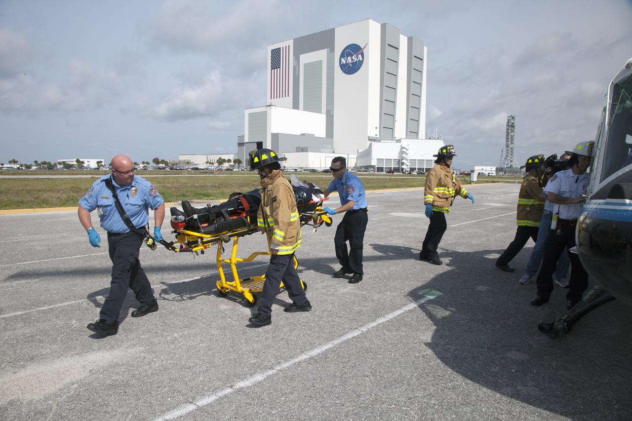 CAPE CANAVERAL, Fla. -- At NASA's Kennedy Space Center in Florida, paramedics and Fire Rescue personnel move a stretcher away from a helicopter after they practiced placing the "volunteer patient" aboard during a training exercise.    The activity taking place in Kennedy's Launch Complex 39 turn-basin parking lot was only one of several drills. It was part of a new training program that was developed by Kennedy's Fire Rescue department along with NASA Aircraft Operations to sharpen the skills needed to help rescue personnel learn how to collaborate with helicopter pilots in taking injured patients to hospitals as quickly as possible. Photo credit: NASA/Dan Casper