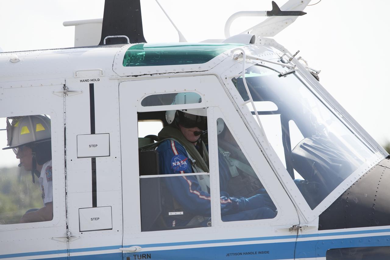 CAPE CANAVERAL, Fla. -- At NASA's Kennedy Space Center in Florida, agency helicopter pilots ensure all is clear before taking off during a training exercise. Helicopter pilot Bill Martin, a URS Federal Technical Services in the agency's Aircraft Operations, is seen in the front seat. Behind Martin on the left, is Mark Huetter, of Chenega Security & Support Solutions. Martin serves as assistant chief of Training for the center's Fire Rescue Department. The activity taking place in Kennedy's Launch Complex 39 turn-basin parking lot was only one of several drills. It was part of a new training program that was developed by Kennedy's Fire Rescue department along with NASA Aircraft Operations to sharpen the skills needed to help rescue personnel learn how to collaborate with helicopter pilots in taking injured patients to hospitals as quickly as possible. Photo credit: NASA/Dan Casper