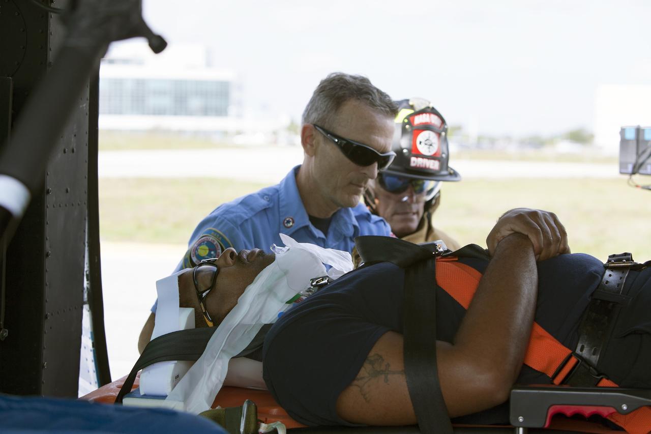 CAPE CANAVERAL, Fla. -- At NASA's Kennedy Space Center in Florida, a "volunteer patient" is carefully placed aboard a NASA helicopter as part of a training exercise. In an actual emergency, the pilots could fly an injured person from Kennedy to a nearby trauma center in minutes. The activity taking place in Kennedy's Launch Complex 39 turn-basin parking lot was only one of several drills. It was part of a new training program that was developed by Kennedy's Fire Rescue department along with NASA Aircraft Operations to sharpen the skills needed to help rescue personnel learn how to collaborate with helicopter pilots in taking injured patients to hospitals as quickly as possible. Photo credit: NASA/Dan Casper
