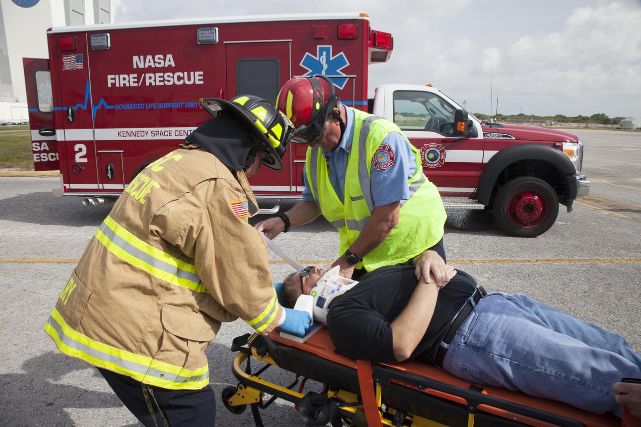 CAPE CANAVERAL, Fla. -- At NASA's Kennedy Space Center in Florida, George Jacobs, NASA's deputy director of Center Operations, serves as a "volunteer patient" and is secured on a stretcher for a simulated emergency operation. The activity taking place in Kennedy's Launch Complex 39 turn-basin parking lot was only one of several drills. It was part of a new training program that was developed by Kennedy's Fire Rescue department along with NASA Aircraft Operations to sharpen the skills needed to help rescue personnel learn how to collaborate with helicopter pilots in taking injured patients to hospitals as quickly as possible. Photo credit: NASA/Dan Casper