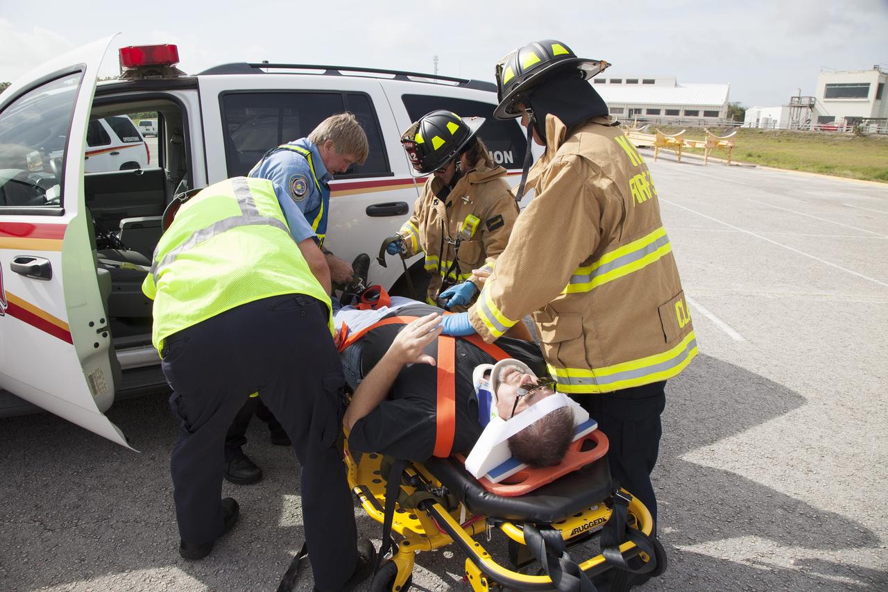 CAPE CANAVERAL, Fla. -- At NASA's Kennedy Space Center in Florida, George Jacobs, NASA's deputy director of Center Operations, serves as a "volunteer patient" and is secured on a stretcher for a simulated emergency operation. The activity taking place in Kennedy's Launch Complex 39 turn-basin parking lot was only one of several drills. It was part of a new training program that was developed by Kennedy's Fire Rescue department along with NASA Aircraft Operations to sharpen the skills needed to help rescue personnel learn how to collaborate with helicopter pilots in taking injured patients to hospitals as quickly as possible. Photo credit: NASA/Dan Casper