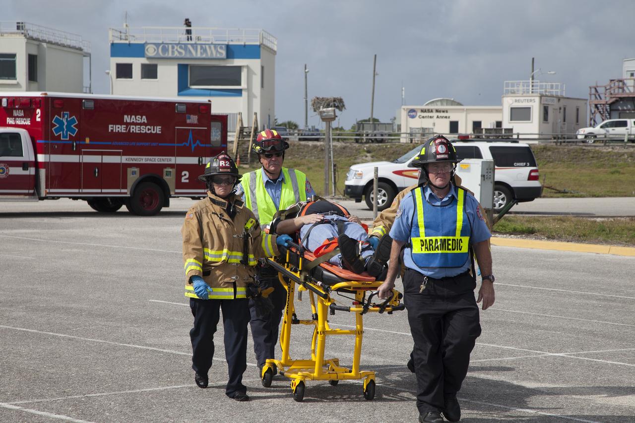 CAPE CANAVERAL, Fla. -- At NASA's Kennedy Space Center in Florida, Paramedics and Fire Rescue personnel move a stretcher to the waiting helicopter as they work quickly to have the patient ready to transport after he was removed from a vehicle.    The activity taking place in Kennedy's Launch Complex 39 turn-basin parking lot was only one of several drills. It was part of a new training program that was developed by Kennedy's Fire Rescue department along with NASA Aircraft Operations to sharpen the skills needed to help rescue personnel learn how to collaborate with helicopter pilots in taking injured patients to hospitals as quickly as possible. Photo credit: NASA/Dan Casper