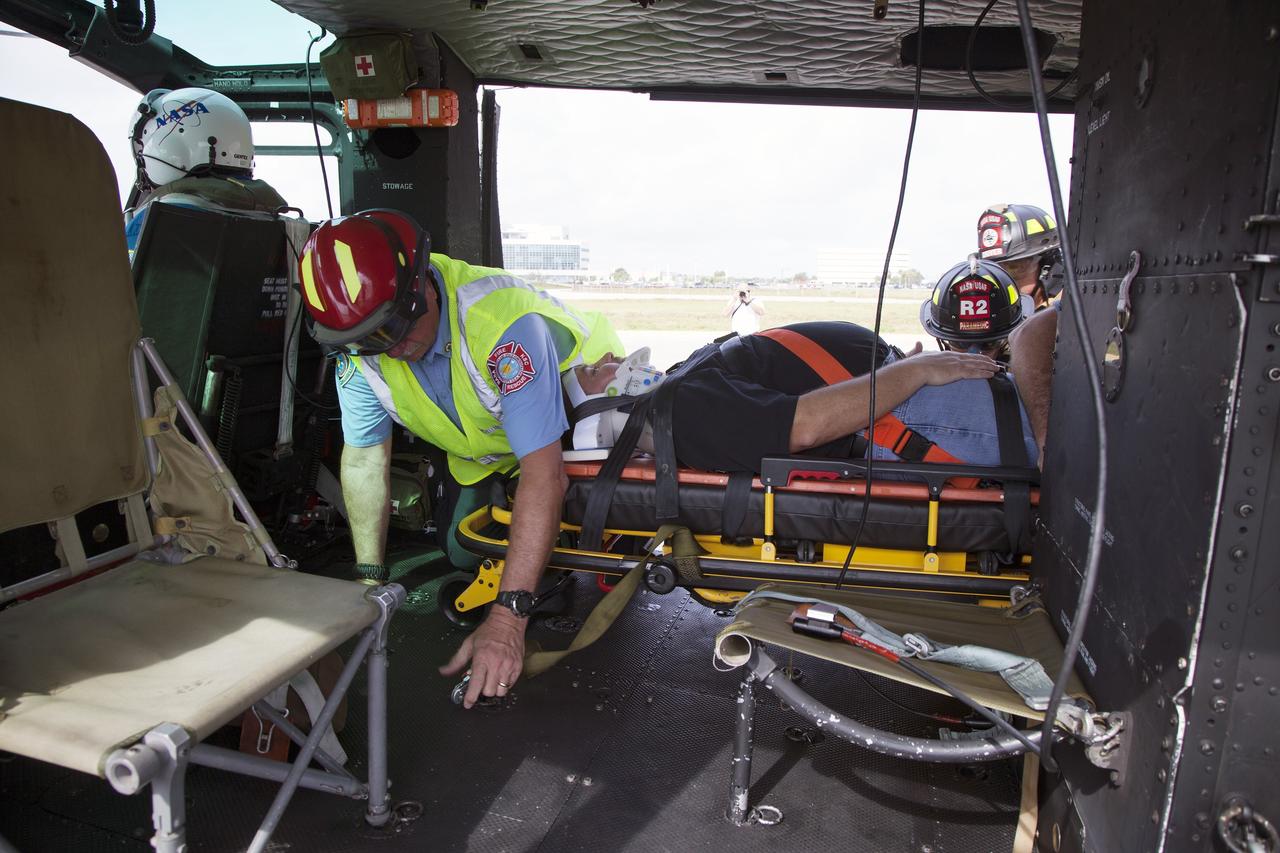 CAPE CANAVERAL, Fla. -- For a training exercise, "volunteer patient" George Jacobs, NASA's deputy director of Center Operations, is carefully placed aboard an agency helicopter at the Kennedy Space Center in Florida. In an actual emergency, the pilots could fly an injured person from Kennedy to a nearby trauma center in minutes. The activity taking place in Kennedy's Launch Complex 39 turn-basin parking lot was only one of several drills. It was part of a new training program that was developed by Kennedy's Fire Rescue department along with NASA Aircraft Operations to sharpen the skills needed to help rescue personnel learn how to collaborate with helicopter pilots in taking injured patients to hospitals as quickly as possible. Photo credit: NASA/Dan Casper