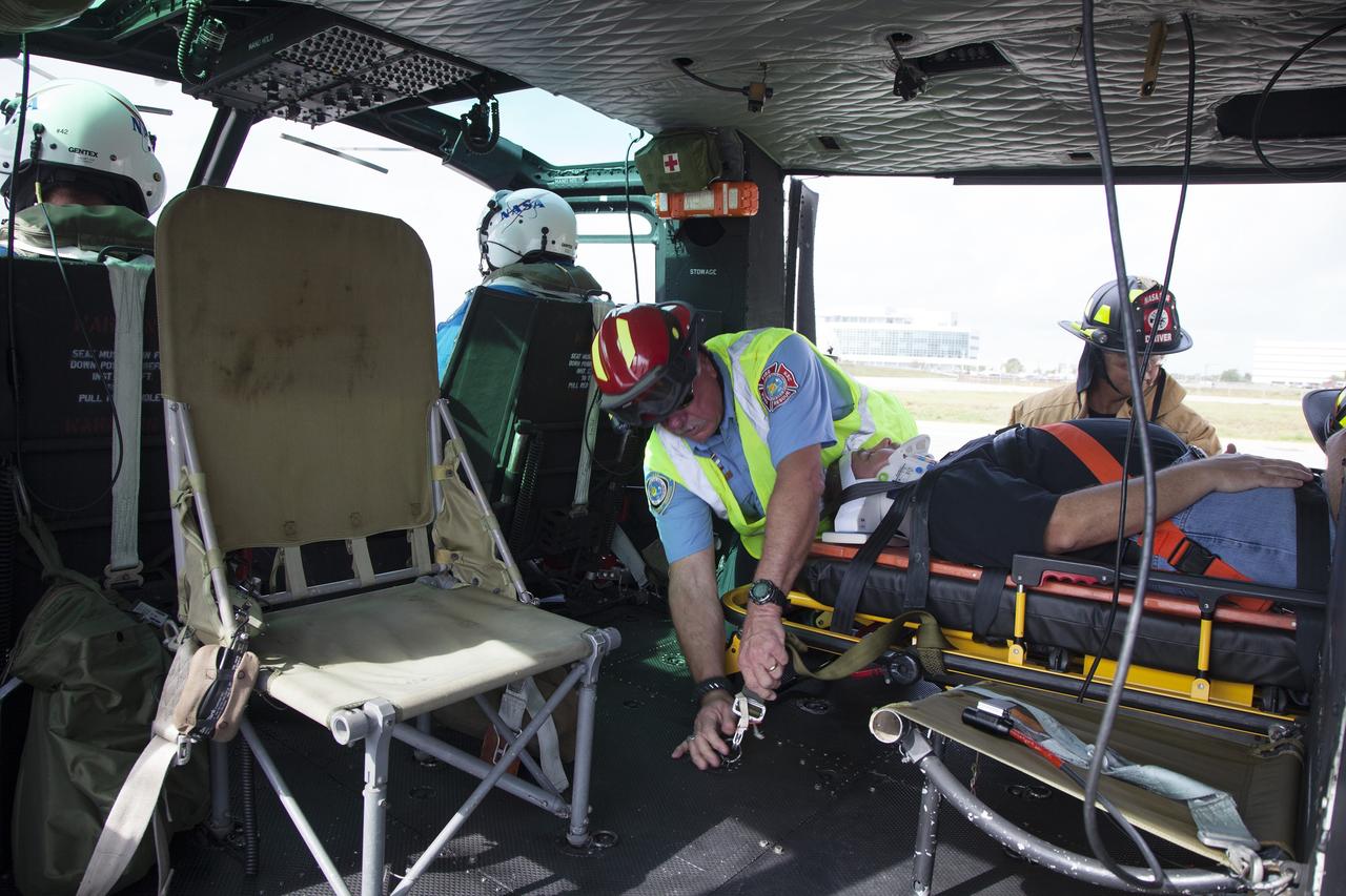 CAPE CANAVERAL, Fla. -- For a training exercise, "volunteer patient" George Jacobs, NASA's deputy director of Center Operations, is carefully placed aboard an agency helicopter at the Kennedy Space Center in Florida. In an actual emergency, the pilots could fly an injured person from Kennedy to a nearby trauma center in minutes. The activity taking place in Kennedy's Launch Complex 39 turn-basin parking lot was only one of several drills. It was part of a new training program that was developed by Kennedy's Fire Rescue department along with NASA Aircraft Operations to sharpen the skills needed to help rescue personnel learn how to collaborate with helicopter pilots in taking injured patients to hospitals as quickly as possible. Photo credit: NASA/Dan Casper