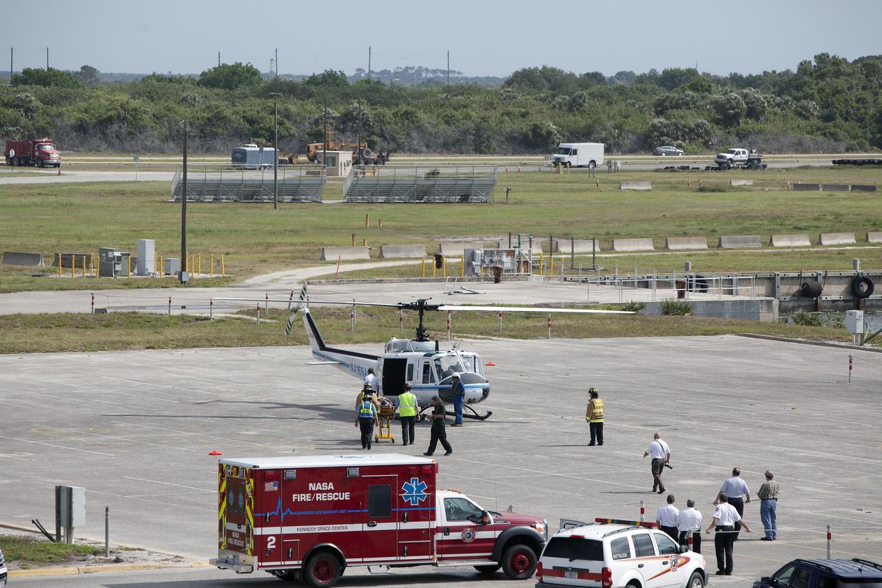 CAPE CANAVERAL, Fla. -- At NASA's Kennedy Space Center in Florida, paramedics and Fire Rescue personnel move a stretcher to the waiting helicopter as they work quickly to have the patient ready to transport five minutes after he was removed from a vehicle.    The activity taking place in Kennedy's Launch Complex 39 turn-basin parking lot was only one of several drills. It was part of a new training program that was developed by Kennedy's Fire Rescue department along with NASA Aircraft Operations to sharpen the skills needed to help rescue personnel learn how to collaborate with helicopter pilots in taking injured patients to hospitals as quickly as possible. Photo credit: NASA/Dan Casper