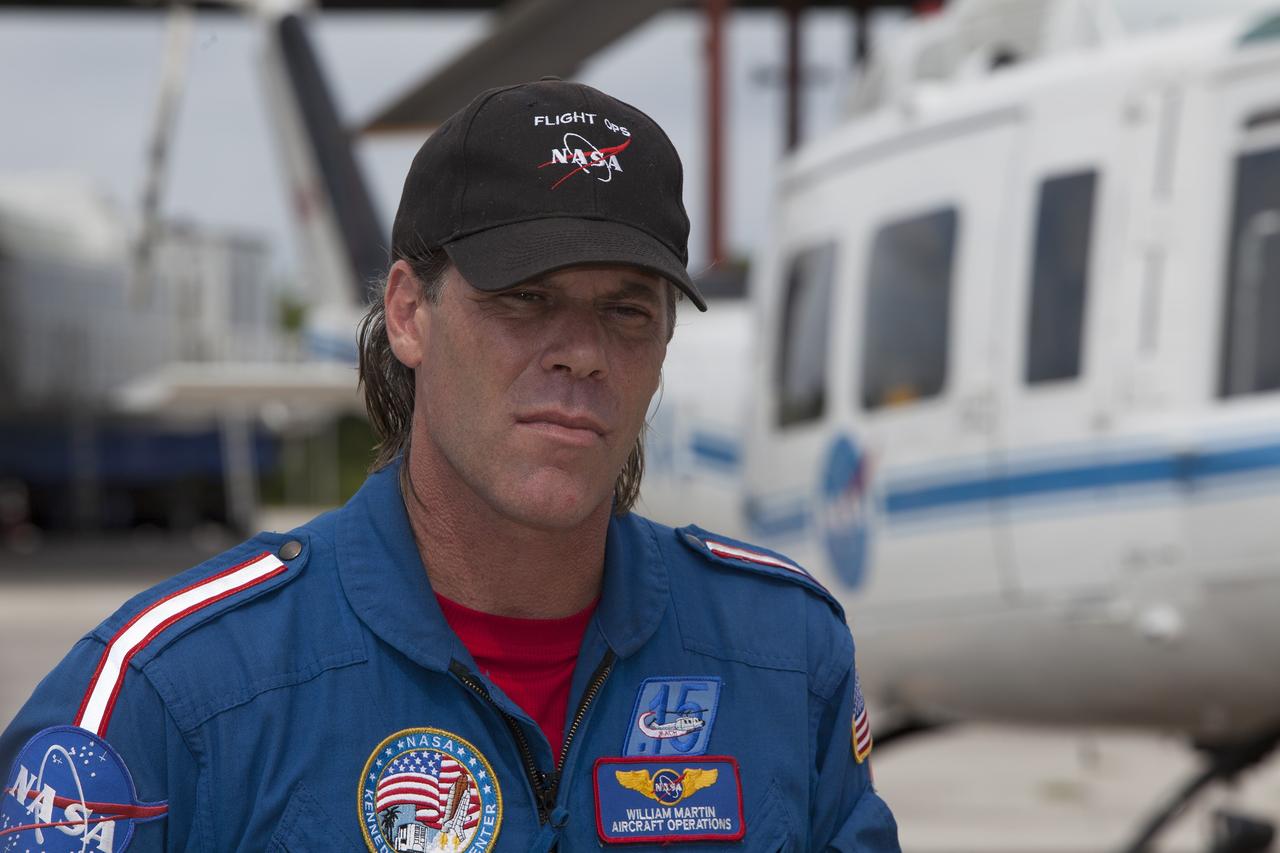 CAPE CANAVERAL, Fla. -- At NASA's Kennedy Space Center in Florida, Bill Martin, a URS Federal Technical Services helicopter pilot in the agency's Aircraft Operations, is interviewed near the Shuttle Landing Facility. He discussed working with spaceport Fire Rescue personnel to develop procedures for using agency helicopters to transport injured patients to a local hospital.    The training activity took place in Kennedy's Launch Complex 39 turn-basin parking lot. It was part of a new training program developed by Kennedy's Fire Rescue department along with NASA Aircraft Operations to sharpen the skills needed to help rescue personnel learn how to collaborate with helicopter pilots in taking injured patients to hospitals as quickly as possible. Photo credit: NASA/Dimitri Gerondidakis