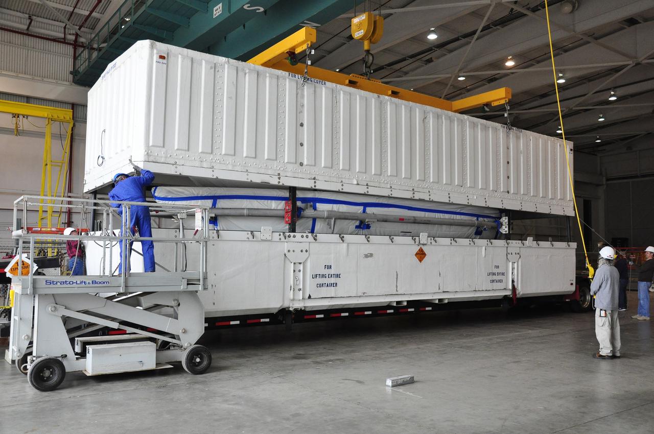 VANDENBERG AIR FORCE BASE, Calif. – Workers hoist the lid off the transportation trailer containing the fairing for NASA's Soil Moisture Active Passive mission, or SMAP, in the Building 836 high bay on Vandenberg Air Force Base in California. The fairing will protect the SMAP spacecraft from the heat and aerodynamic pressure generated during its ascent to orbit aboard a United Launch Alliance Delta II rocket from Space Launch Complex 2. SMAP will provide global measurements of soil moisture and its freeze/thaw state. These measurements will be used to enhance understanding of processes that link the water, energy and carbon cycles, and to extend the capabilities of weather and climate prediction models. SMAP data will also be used to quantify net carbon flux in boreal landscapes and to develop improved flood prediction and drought monitoring capabilities. Launch is scheduled for November 2014. To learn more about SMAP, visit http://smap.jpl.nasa.gov. Photo credit: NASA/Randy Beaudoin