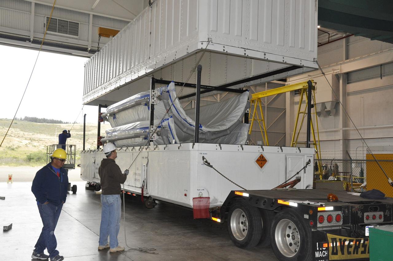 VANDENBERG AIR FORCE BASE, Calif. – A worker steadies the lid of the transportation trailer containing the fairing for NASA's Soil Moisture Active Passive mission, or SMAP, in the Building 836 high bay on Vandenberg Air Force Base in California. The fairing will protect the SMAP spacecraft from the heat and aerodynamic pressure generated during its ascent to orbit aboard a United Launch Alliance Delta II rocket from Space Launch Complex 2. SMAP will provide global measurements of soil moisture and its freeze/thaw state. These measurements will be used to enhance understanding of processes that link the water, energy and carbon cycles, and to extend the capabilities of weather and climate prediction models. SMAP data will also be used to quantify net carbon flux in boreal landscapes and to develop improved flood prediction and drought monitoring capabilities. Launch is scheduled for November 2014. To learn more about SMAP, visit http://smap.jpl.nasa.gov. Photo credit: NASA/Randy Beaudoin