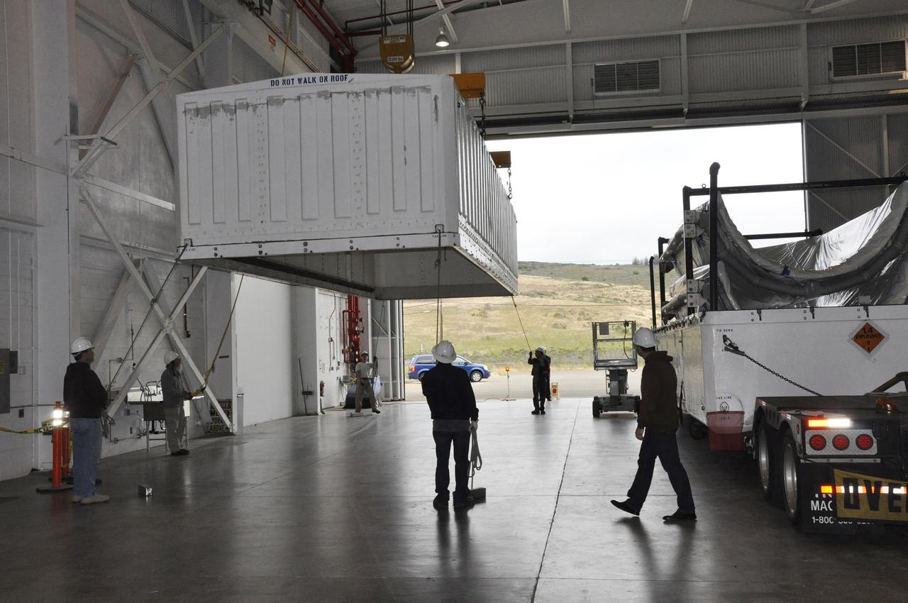 VANDENBERG AIR FORCE BASE, Calif. – The lid is removed from the transportation trailer containing the fairing for NASA's Soil Moisture Active Passive mission, or SMAP, in the Building 836 high bay on Vandenberg Air Force Base in California. The fairing will protect the SMAP spacecraft from the heat and aerodynamic pressure generated during its ascent to orbit aboard a United Launch Alliance Delta II rocket from Space Launch Complex 2. SMAP will provide global measurements of soil moisture and its freeze/thaw state. These measurements will be used to enhance understanding of processes that link the water, energy and carbon cycles, and to extend the capabilities of weather and climate prediction models. SMAP data will also be used to quantify net carbon flux in boreal landscapes and to develop improved flood prediction and drought monitoring capabilities. Launch is scheduled for November 2014. To learn more about SMAP, visit http://smap.jpl.nasa.gov. Photo credit: NASA/Randy Beaudoin