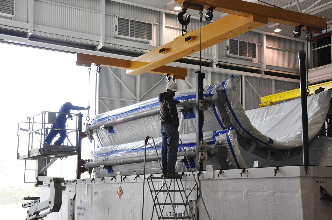 VANDENBERG AIR FORCE BASE, Calif. – Workers prepare to lift the fairing for NASA's Soil Moisture Active Passive mission, or SMAP, from a transportation trailer in the Building 836 high bay on Vandenberg Air Force Base in California. The fairing will protect the SMAP spacecraft from the heat and aerodynamic pressure generated during its ascent to orbit aboard a United Launch Alliance Delta II rocket from Space Launch Complex 2. SMAP will provide global measurements of soil moisture and its freeze/thaw state. These measurements will be used to enhance understanding of processes that link the water, energy and carbon cycles, and to extend the capabilities of weather and climate prediction models. SMAP data will also be used to quantify net carbon flux in boreal landscapes and to develop improved flood prediction and drought monitoring capabilities. Launch is scheduled for November 2014. To learn more about SMAP, visit http://smap.jpl.nasa.gov. Photo credit: NASA/Randy Beaudoin