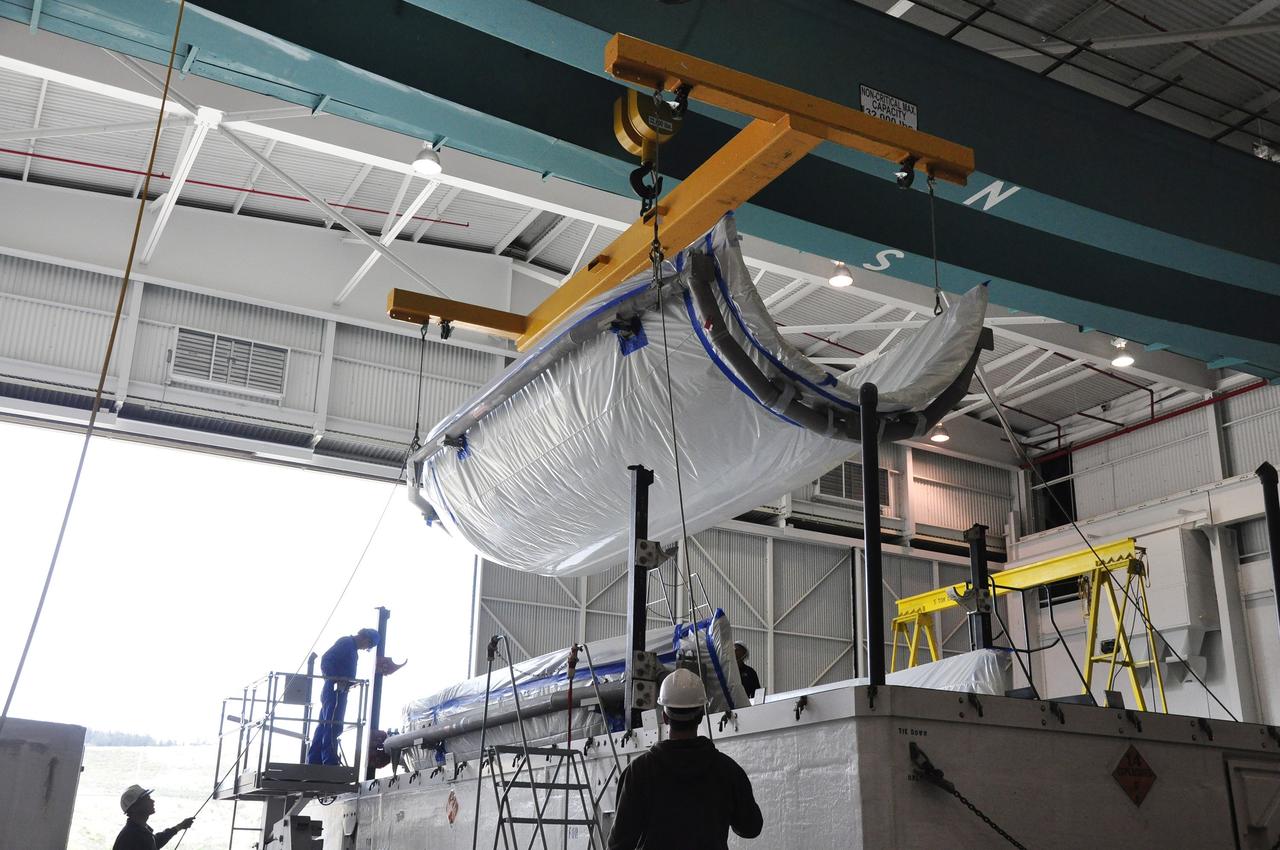 VANDENBERG AIR FORCE BASE, Calif. – Workers lift a section of the fairing for NASA's Soil Moisture Active Passive mission, or SMAP, from a transportation trailer in the Building 836 high bay on Vandenberg Air Force Base in California. The fairing will protect the SMAP spacecraft from the heat and aerodynamic pressure generated during its ascent to orbit aboard a United Launch Alliance Delta II rocket from Space Launch Complex 2. SMAP will provide global measurements of soil moisture and its freeze/thaw state. These measurements will be used to enhance understanding of processes that link the water, energy and carbon cycles, and to extend the capabilities of weather and climate prediction models. SMAP data will also be used to quantify net carbon flux in boreal landscapes and to develop improved flood prediction and drought monitoring capabilities. Launch is scheduled for November 2014. To learn more about SMAP, visit http://smap.jpl.nasa.gov. Photo credit: NASA/Randy Beaudoin