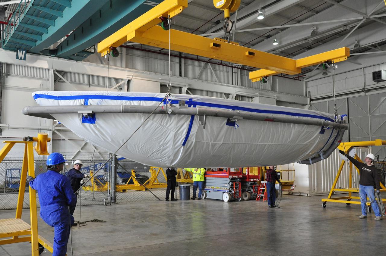 VANDENBERG AIR FORCE BASE, Calif. – Workers move a section of the fairing for NASA's Soil Moisture Active Passive mission, or SMAP, across the floor of the Building 836 high bay on Vandenberg Air Force Base in California. The fairing will protect the SMAP spacecraft from the heat and aerodynamic pressure generated during its ascent to orbit aboard a United Launch Alliance Delta II rocket from Space Launch Complex 2. SMAP will provide global measurements of soil moisture and its freeze/thaw state. These measurements will be used to enhance understanding of processes that link the water, energy and carbon cycles, and to extend the capabilities of weather and climate prediction models. SMAP data will also be used to quantify net carbon flux in boreal landscapes and to develop improved flood prediction and drought monitoring capabilities. Launch is scheduled for November 2014. To learn more about SMAP, visit http://smap.jpl.nasa.gov. Photo credit: NASA/Randy Beaudoin