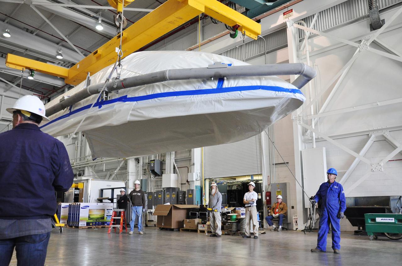 VANDENBERG AIR FORCE BASE, Calif. – A section of the fairing for NASA's Soil Moisture Active Passive mission, or SMAP, secured to a lifting device, glides across the floor of the Building 836 high bay on Vandenberg Air Force Base in California. The fairing will protect the SMAP spacecraft from the heat and aerodynamic pressure generated during its ascent to orbit aboard a United Launch Alliance Delta II rocket from Space Launch Complex 2. SMAP will provide global measurements of soil moisture and its freeze/thaw state. These measurements will be used to enhance understanding of processes that link the water, energy and carbon cycles, and to extend the capabilities of weather and climate prediction models. SMAP data will also be used to quantify net carbon flux in boreal landscapes and to develop improved flood prediction and drought monitoring capabilities. Launch is scheduled for November 2014. To learn more about SMAP, visit http://smap.jpl.nasa.gov. Photo credit: NASA/Randy Beaudoin
