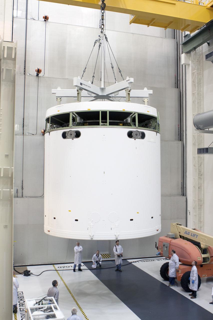 CAPE CANAVERAL, Fla. -- Inside the Operations and Checkout Building high bay at NASA's Kennedy Space Center in Florida, NASA and Lockheed Martin engineers and technicians monitor the progress as a crane is used to move the Orion service module to the Final Assembly and System Testing, or FAST, cell further down the aisle. The Orion crew module will be stacked on the service module in the FAST cell and then both modules will be put through their final system tests for Exploration Flight Test-1, or EFT-1, before rolling out of the facility for integration with the United Launch Alliance Delta IV Heavy rocket.    Orion is the exploration spacecraft designed to carry astronauts to destinations not yet explored by humans, including an asteroid and Mars. It will have emergency abort capability, sustain the crew during space travel and provide safe re-entry from deep space return velocities. The first unpiloted test flight of Orion, EFT-1, is scheduled to launch later this year atop a Delta IV rocket from Cape Canaveral Air Force Station in Florida to an altitude of 3,600 miles above the Earth's surface. The two-orbit, four-hour flight test will help engineers evaluate the systems critical to crew safety including the heat shield, parachute system and launch abort system. For more information, visit http://www.nasa.gov/orion. Photo credit: NASA/Glenn Benson
