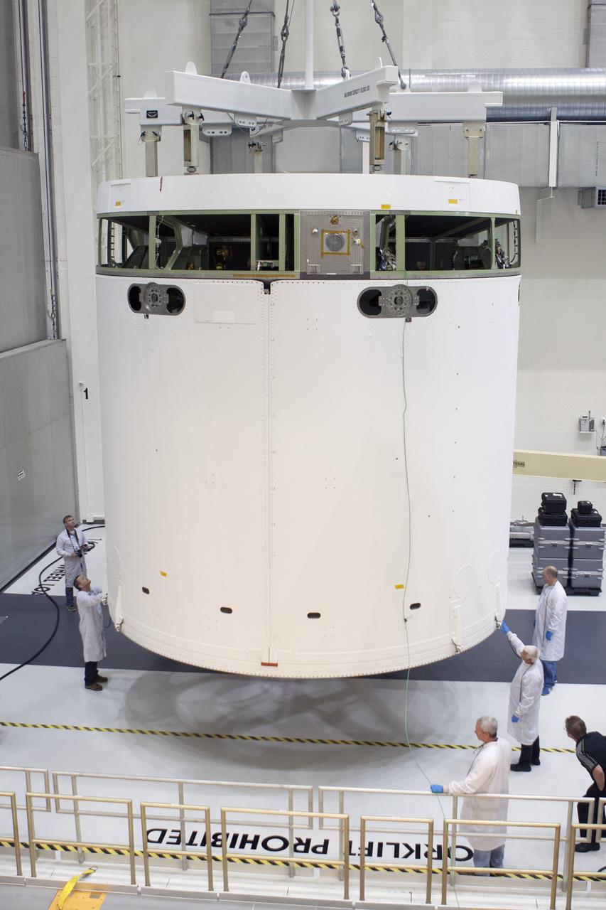 CAPE CANAVERAL, Fla. -- Inside the Operations and Checkout Building high bay at NASA's Kennedy Space Center in Florida, NASA and Lockheed Martin engineers and technicians help guide the Orion service module into the Final Assembly and System Testing, or FAST, cell. The Orion crew module will be stacked on the service module in the FAST cell and then both modules will be put through their final system tests for Exploration Flight Test-1, or EFT-1, before rolling out of the facility for integration with the United Launch Alliance Delta IV Heavy rocket.     Orion is the exploration spacecraft designed to carry astronauts to destinations not yet explored by humans, including an asteroid and Mars. It will have emergency abort capability, sustain the crew during space travel and provide safe re-entry from deep space return velocities. The first unpiloted test flight of Orion, EFT-1, is scheduled to launch later this year atop a Delta IV rocket from Cape Canaveral Air Force Station in Florida to an altitude of 3,600 miles above the Earth's surface. The two-orbit, four-hour flight test will help engineers evaluate the systems critical to crew safety including the heat shield, parachute system and launch abort system. For more information, visit http://www.nasa.gov/orion. Photo credit: NASA/Glenn Benson