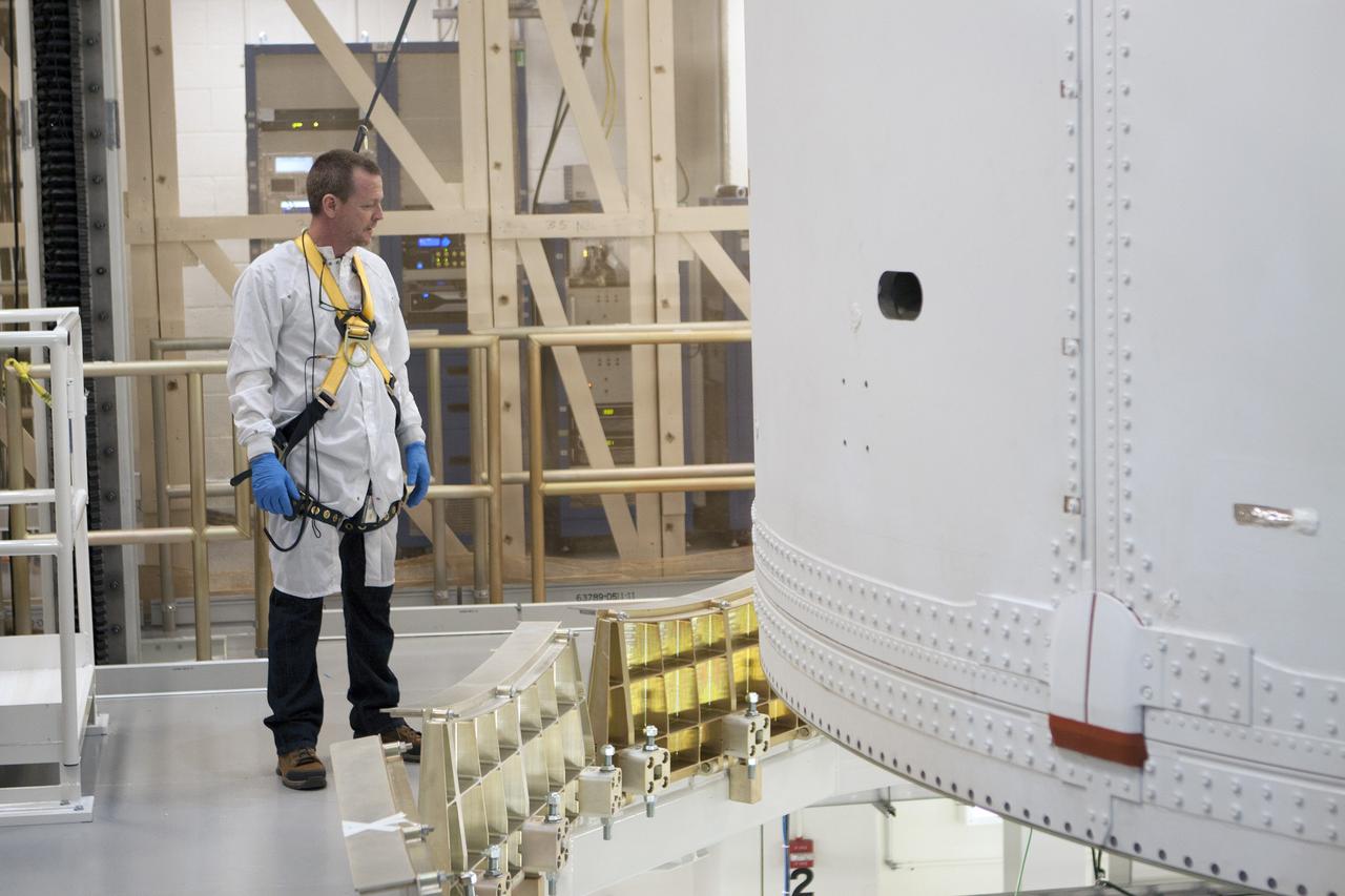 CAPE CANAVERAL, Fla. -- Inside the Operations and Checkout Building high bay at NASA's Kennedy Space Center in Florida, a Lockheed Martin technician monitors the progress as a crane lowers the Orion service module into the Final Assembly and System Testing, or FAST, cell further down the aisle. The Orion crew module will be stacked on the service module in the FAST cell and then both modules will be put through their final system tests for Exploration Flight Test-1, or EFT-1, before rolling out of the facility for integration with the United Launch Alliance Delta IV Heavy rocket.     Orion is the exploration spacecraft designed to carry astronauts to destinations not yet explored by humans, including an asteroid and Mars. It will have emergency abort capability, sustain the crew during space travel and provide safe re-entry from deep space return velocities. The first unpiloted test flight of Orion, EFT-1, is scheduled to launch later this year atop a Delta IV rocket from Cape Canaveral Air Force Station in Florida to an altitude of 3,600 miles above the Earth's surface. The two-orbit, four-hour flight test will help engineers evaluate the systems critical to crew safety including the heat shield, parachute system and launch abort system. For more information, visit http://www.nasa.gov/orion. Photo credit: NASA/Glenn Benson