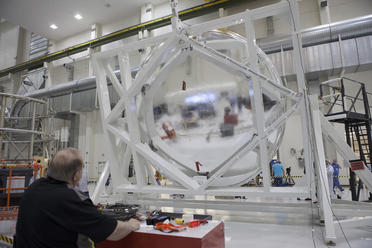 CAPE CANAVERAL, Fla. -- Inside the Operations and Checkout Building high bay at NASA's Kennedy Space Center in Florida, NASA and Lockheed Martin technicians and engineers conduct a center of gravity, or CG, test on the Orion crew module. The CG tool will measure the exact location of the vehicle's center of gravity. This test is important as it affects the handling and control characteristics of the vehicle. The Orion crew module will be stacked on the service module in the Final Assembly and System Testing, or FAST, cell and then both modules will be put through their final system tests for Exploration Flight Test-1, or EFT-1, before rolling out of the facility for integration with the United Launch Alliance Delta IV Heavy rocket.      Orion is the exploration spacecraft designed to carry astronauts to destinations not yet explored by humans, including an asteroid and Mars. It will have emergency abort capability, sustain the crew during space travel and provide safe re-entry from deep space return velocities. The first unpiloted test flight of Orion, EFT-1, is scheduled to launch later this year atop a Delta IV rocket from Cape Canaveral Air Force Station in Florida to an altitude of 3,600 miles above the Earth's surface. The two-orbit, four-hour flight test will help engineers evaluate the systems critical to crew safety including the heat shield, parachute system and launch abort system. For more information, visit http://www.nasa.gov/orion. Photo credit: NASA/Glenn Benson
