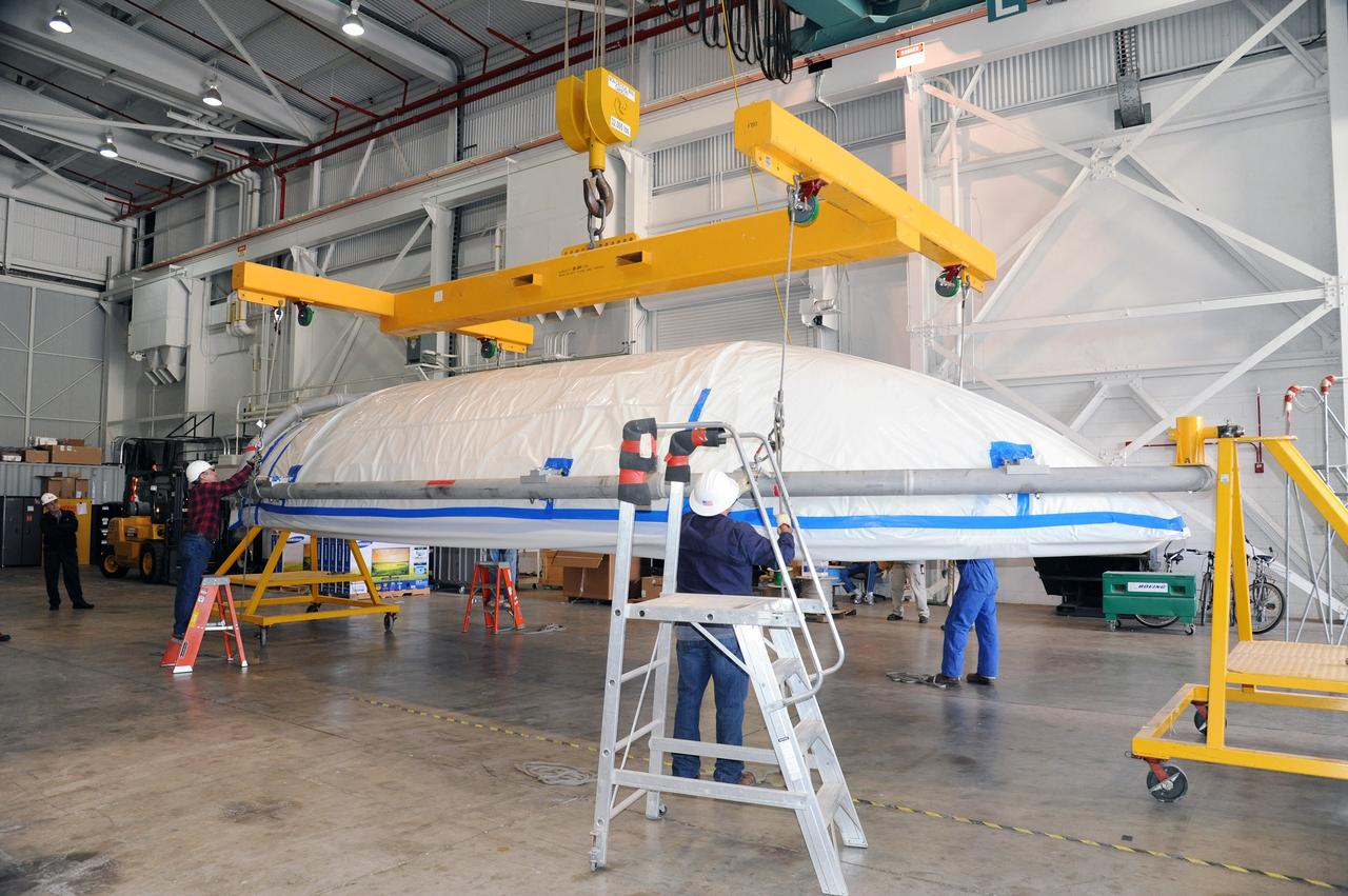 VANDENBERG AIR FORCE BASE, Calif. – Workers rotate a half section of the 10-foot-diameter fairing for NASA's Soil Moisture Active Passive mission, or SMAP, in a lifting device in the Building 836 high bay on south Vandenberg Air Force Base in California.    The fairing will protect the SMAP spacecraft from the heat and aerodynamic pressure generated during its ascent to orbit aboard a United Launch Alliance Delta II rocket from Space Launch Complex 2. SMAP will provide global measurements of soil moisture and its freeze/thaw state. These measurements will be used to enhance understanding of processes that link the water, energy and carbon cycles, and to extend the capabilities of weather and climate prediction models. SMAP data will also be used to quantify net carbon flux in boreal landscapes and to develop improved flood prediction and drought monitoring capabilities. Launch is scheduled for November 2014. To learn more about SMAP, visit http://smap.jpl.nasa.gov.  Photo credit: NASA/U.S. Air Force 30th Space Wing