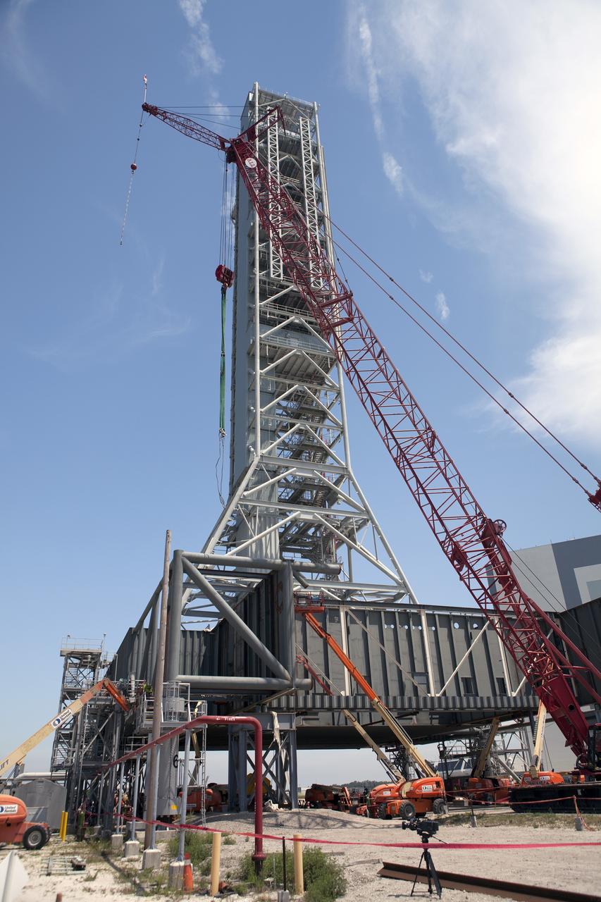CAPE CANAVERAL, Fla. – Modifications continue on the Mobile Launcher, or ML, at the Mobile Launcher Park Site at NASA’s Kennedy Space Center in Florida. Construction workers on lifts cut through sections of the steel beams to prepare them for removal. The ML is being modified and strengthened to accommodate the weight, size and thrust at launch of NASA's Space Launch System, or SLS, and Orion spacecraft.    In 2013, the agency awarded a contract to J.P. Donovan Construction Inc. of Rockledge, Fla., to modify the ML, which is one of the key elements of ground support equipment that is being upgraded by the Ground Systems Development and Operations Program office at Kennedy. The existing 24-foot exhaust hole is being enlarged and strengthened for the larger, heavier SLS rocket. The ML will carry the SLS rocket and Orion spacecraft to Launch Pad 39B for its first mission, Exploration Mission-1, in 2017. Photo credit: NASA/Dimitri Gerondidakis