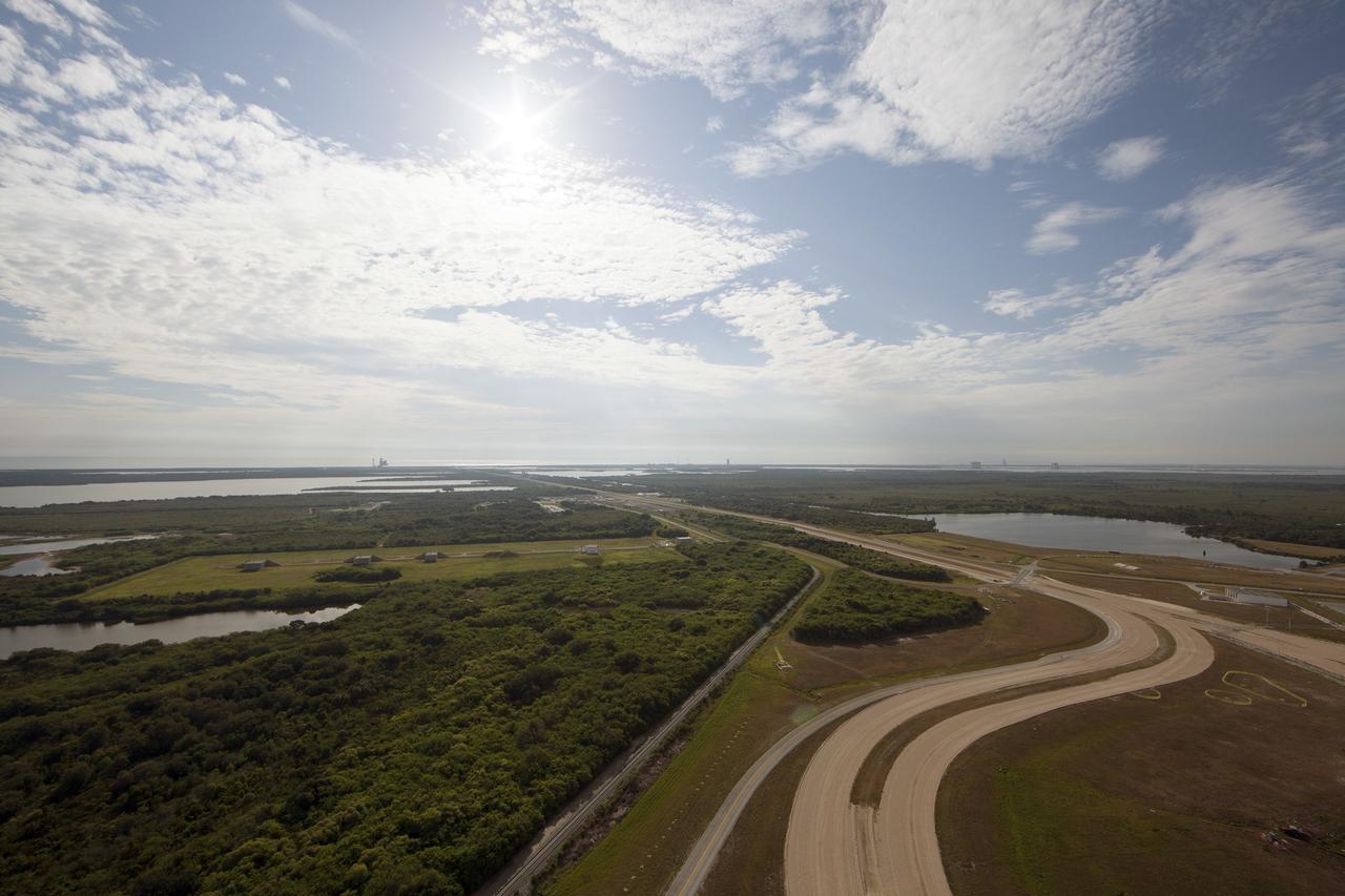 CAPE CANAVERAL, Fla. -- Modifications continue on the Mobile Launcher, or ML, at the Mobile Launcher Park Site at NASA’s Kennedy Space Center in Florida. In view from the top of the ML is the crawlerway that leads to Launch Pads 39A and 39B. The ML is being modified and strengthened to accommodate the weight, size and thrust at launch of NASA's Space Launch System, or SLS, and Orion spacecraft.    In 2013, the agency awarded a contract to J.P. Donovan Construction Inc. of Rockledge, Fla., to modify the ML, which is one of the key elements of ground support equipment that is being upgraded by the Ground Systems Development and Operations Program office at Kennedy. The existing 24-foot exhaust hole is being enlarged and strengthened for the larger, heavier SLS rocket. The ML will carry the SLS rocket and Orion spacecraft to Launch Pad 39B for its first mission, Exploration Mission-1, in 2017. Photo credit: NASA/Daniel Casper