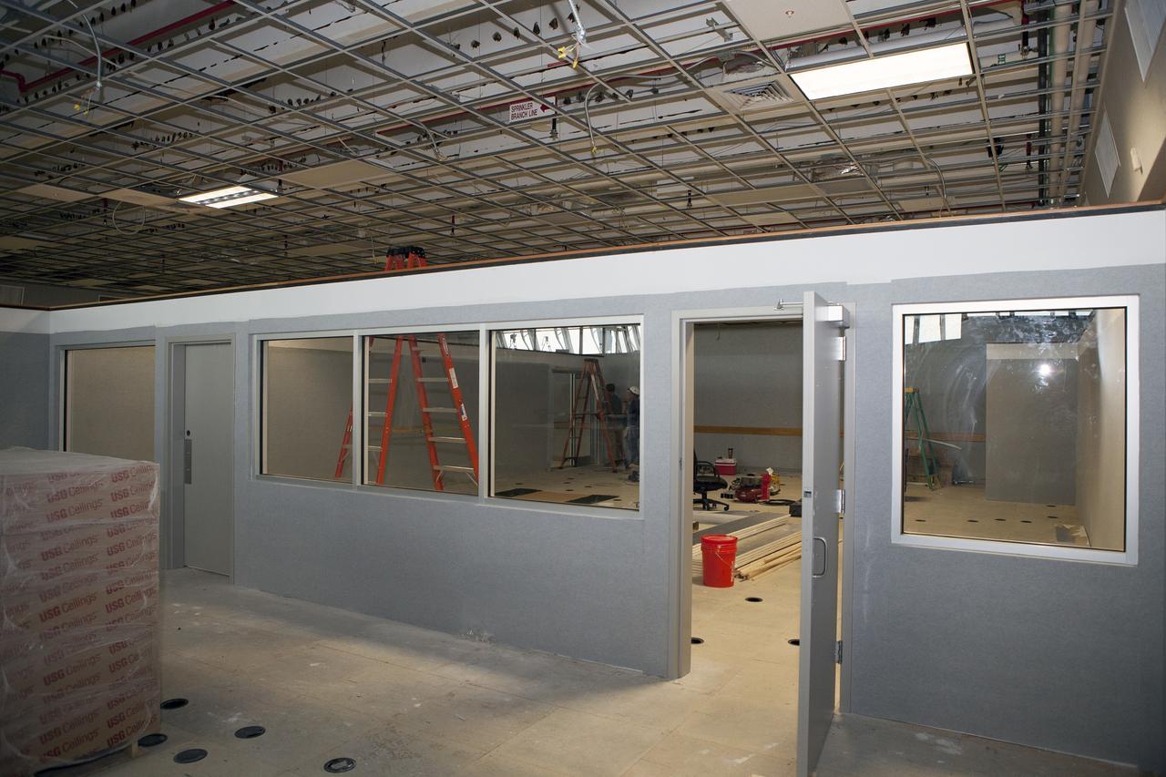 CAPE CANAVERAL, Fla. – Inside Firing Room 4 in the Launch Control Center at NASA's Kennedy Space Center in Florida, construction workers are completing the inner walls that separate the four firing rooms and the window framing and doorways are nearing completion. Three rows of upper level management consoles remain and could be used as a fifth firing room. The Ground Systems Development and Operations Program is overseeing the efforts to create a new firing room based on a multi-user concept.      The design of Firing Room 4 will incorporate five control room areas that are flexible to meet current and future NASA and commercial user requirements. The equipment and most of the consoles from Firing Room 4 were moved to Firing Room 2 for possible future reuse. Photo credit: NASA/Daniel Casper