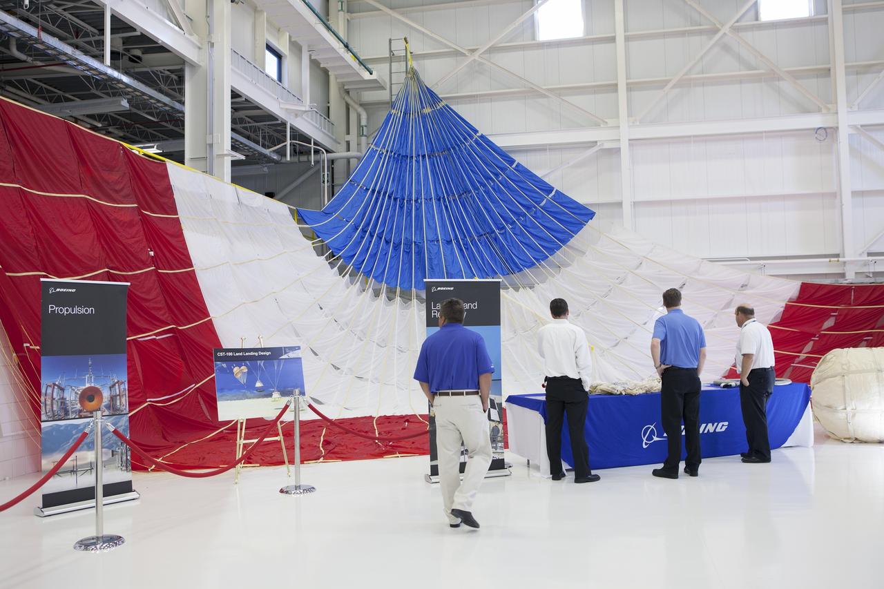 CAPE CANAVERAL, Fla. – A parachute to be used by The Boeing Company's CST-100 is discussed by company officials during a ceremony inside Orbiter Processing Facility 3 at NASA's Kennedy Space Center in Florida. Photo credit: NASA/Kim Shiflett