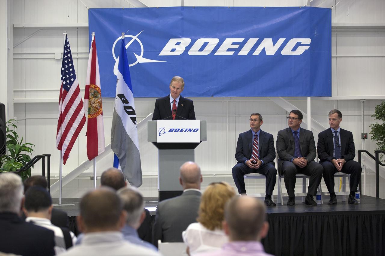 CAPE CANAVERAL, Fla. – U.S. Sen. Bill Nelson of Florida discusses The Boeing Company's CST-100 spacecraft during a ceremony inside Orbiter Processing Facility 3 at NASA's Kennedy Space Center in Florida. Looking on are, from left, John Elbon, Boeing's vice president general manager of Boeing Space Systems,, John Mulholland, Boeing's program manager for the CST-100, and Chris Ferguson, Boeing's director of Crew and Mission Operations. Photo credit: NASA/Kim Shiflett