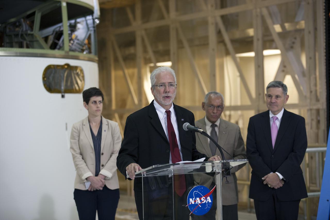 CAPE CANAVERAL, Fla. – Mark Geyer, NASA Orion Program manager, along with NASA Administrator Charlie Bolden, to his right, and Kennedy Space Center Director Bob Cabana help mark the T-6 months and counting to the launch of Orion on Exploration Flight Test-1, or EFT-1, inside the Operations and Checkout Building high bay at NASA's Kennedy Space Center in Florida. At left is Rachel Kraft, NASA Public Affairs Officer. The crew module has been stacked on the service module in the Final Assembly and System Testing cell. EFT-1 will provide engineers with data about the heat shield's ability to protect Orion and its future crews from the 4,000-degree heat of reentry and an ocean splashdown following the spacecraft’s 20,000-mph reentry from space. Data gathered during the flight will inform decisions about design improvements on the heat shield and other Orion systems, and authenticate existing computer models and new approaches to space systems design and development. This process is critical to reducing overall risks and costs of future Orion missions.    Orion is the exploration spacecraft designed to carry astronauts to destinations not yet explored by humans, including an asteroid and Mars. It will have emergency abort capability, sustain the crew during space travel and provide safe re-entry from deep space return velocities. The first unpiloted test flight of the Orion is scheduled to launch later this year atop a Delta IV rocket from Cape Canaveral Air Force Station in Florida to an altitude of 3,600 miles above the Earth's surface. The two-orbit, four-hour flight test will help engineers evaluate the systems critical to crew safety including the heat shield, parachute system and launch abort system. For more information, visit http://www.nasa.gov/orion. Photo credit: NASA/Kim Shiflett