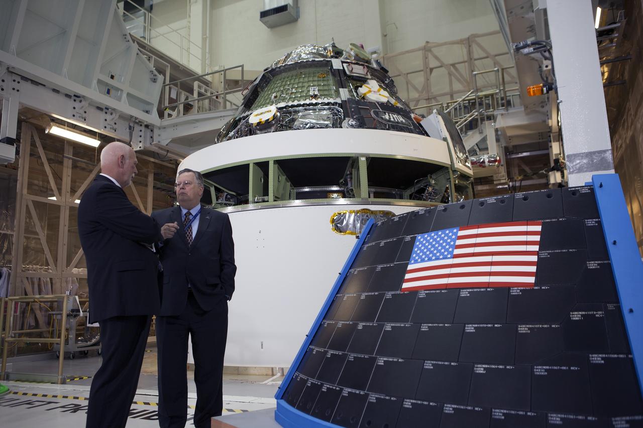 CAPE CANAVERAL, Fla. – Cleon Lacefield, Lockheed Martin Orion Program manager, at right, helps mark the T-6 months and counting to the launch of Orion on Exploration Flight Test-1, or EFT-1, inside the Operations and Checkout Building high bay at NASA's Kennedy Space Center in Florida. In view behind him is the crew module stacked on the service module in the Final Assembly and System Testing cell. EFT-1 will provide engineers with data about the heat shield's ability to protect Orion and its future crews from the 4,000-degree heat of reentry and an ocean splashdown following the spacecraft’s 20,000-mph reentry from space. Data gathered during the flight will inform decisions about design improvements on the heat shield and other Orion systems, and authenticate existing computer models and new approaches to space systems design and development. This process is critical to reducing overall risks and costs of future Orion missions.    Orion is the exploration spacecraft designed to carry astronauts to destinations not yet explored by humans, including an asteroid and Mars. It will have emergency abort capability, sustain the crew during space travel and provide safe re-entry from deep space return velocities. The first unpiloted test flight of the Orion is scheduled to launch later this year atop a Delta IV rocket from Cape Canaveral Air Force Station in Florida to an altitude of 3,600 miles above the Earth's surface. The two-orbit, four-hour flight test will help engineers evaluate the systems critical to crew safety including the heat shield, parachute system and launch abort system. For more information, visit http://www.nasa.gov/orion. Photo credit: NASA/Kim Shiflett
