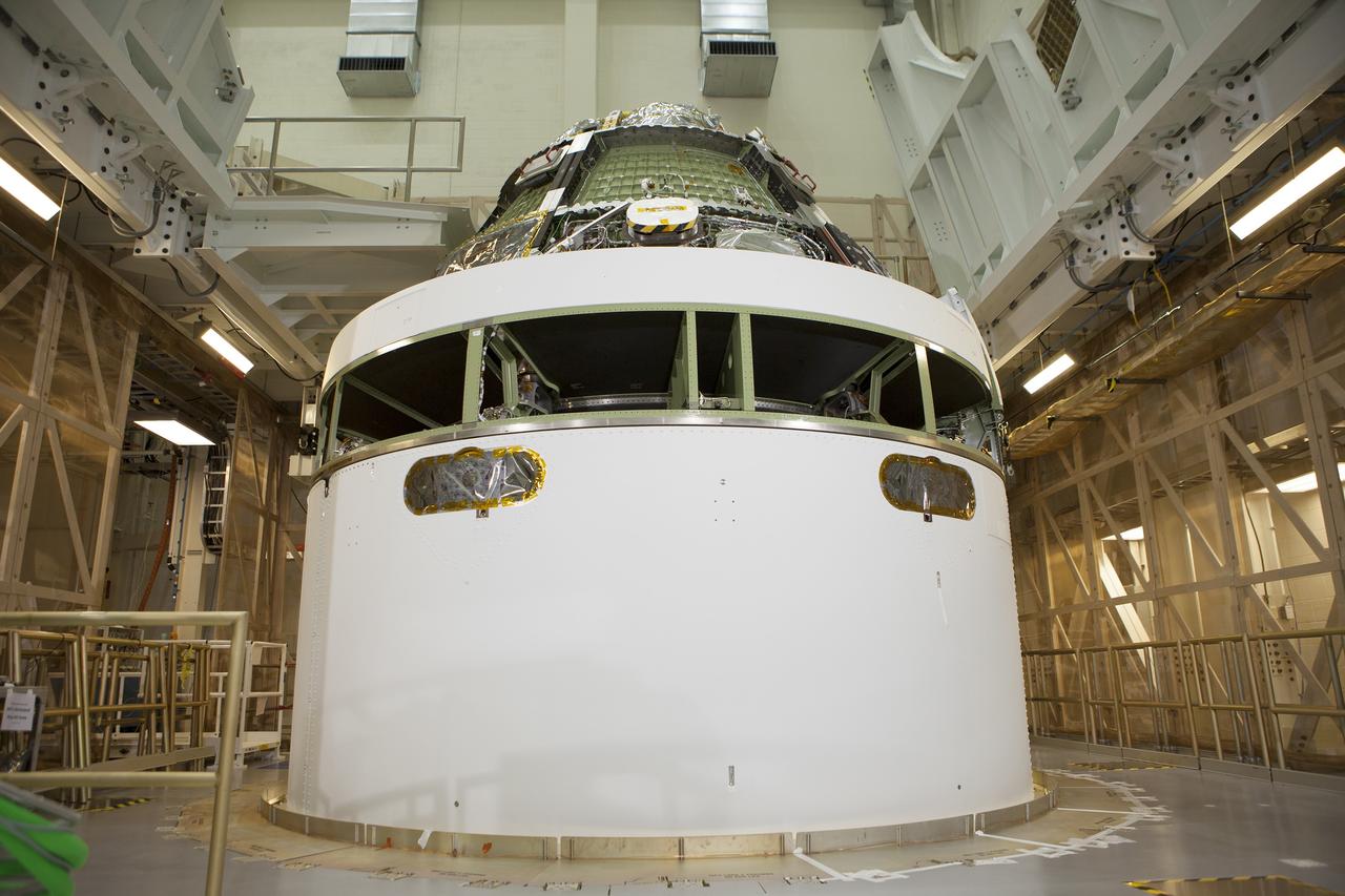 CAPE CANAVERAL, Fla. – Inside the Operations and Checkout Building high bay at NASA's Kennedy Space Center in Florida, the Orion crew module has been stacked on the service module in the Final Assembly and System Testing cell in preparation for final system tests for Exploration Flight Test-1, or EFT-1, prior to rolling out of the facility for integration with the United Launch Alliance Delta IV Heavy rocket. EFT-1 will provide engineers with data about the heat shield's ability to protect Orion and its future crews from the 4,000-degree heat of reentry and an ocean splashdown following the spacecraft’s 20,000-mph reentry from space. Data gathered during the flight will inform decisions about design improvements on the heat shield and other Orion systems, and authenticate existing computer models and new approaches to space systems design and development. This process is critical to reducing overall risks and costs of future Orion missions.    Orion is the exploration spacecraft designed to carry astronauts to destinations not yet explored by humans, including an asteroid and Mars. It will have emergency abort capability, sustain the crew during space travel and provide safe re-entry from deep space return velocities. The first unpiloted test flight of the Orion is scheduled to launch later this year atop a Delta IV rocket from Cape Canaveral Air Force Station in Florida to an altitude of 3,600 miles above the Earth's surface. The two-orbit, four-hour flight test will help engineers evaluate the systems critical to crew safety including the heat shield, parachute system and launch abort system. For more information, visit http://www.nasa.gov/orion. Photo credit: NASA/Kim Shiflett