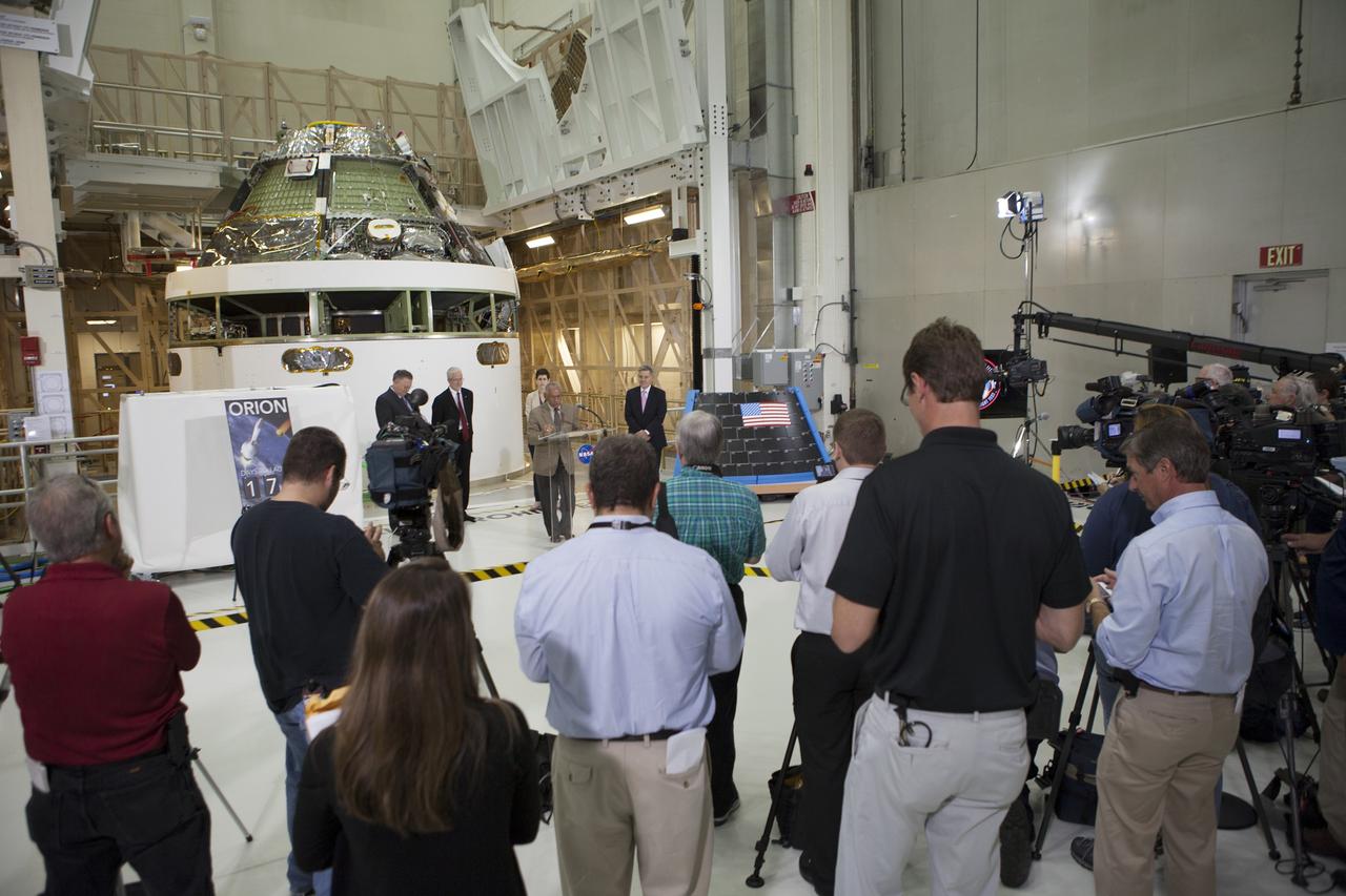 CAPE CANAVERAL, Fla. – Members of the media listen as NASA Administrator Charlie Bolden marks the T-6 months and counting to the launch of Orion on Exploration Flight Test-1, or EFT-1, during a visit to the Operations and Checkout Building high bay at NASA's Kennedy Space Center in Florida. To his right is Kennedy Director Bob Cabana. To his left are Cleon Lacefield, Lockheed Martin Orion Program manager, and Mark Geyer, NASA Orion Program manager. Behind them is the crew module stacked on the service module in the Final Assembly and System Testing cell. EFT-1 will provide engineers with data about the heat shield's ability to protect Orion and its future crews from the 4,000-degree heat of reentry and an ocean splashdown following the spacecraft’s 20,000-mph reentry from space. Data gathered during the flight will inform decisions about design improvements on the heat shield and other Orion systems, and authenticate existing computer models and new approaches to space systems design and development. This process is critical to reducing overall risks and costs of future Orion missions.    Orion is the exploration spacecraft designed to carry astronauts to destinations not yet explored by humans, including an asteroid and Mars. It will have emergency abort capability, sustain the crew during space travel and provide safe re-entry from deep space return velocities. The first unpiloted test flight of the Orion is scheduled to launch later this year atop a Delta IV rocket from Cape Canaveral Air Force Station in Florida to an altitude of 3,600 miles above the Earth's surface. The two-orbit, four-hour flight test will help engineers evaluate the systems critical to crew safety including the heat shield, parachute system and launch abort system. For more information, visit http://www.nasa.gov/orion. Photo credit: NASA/Kim Shiflett