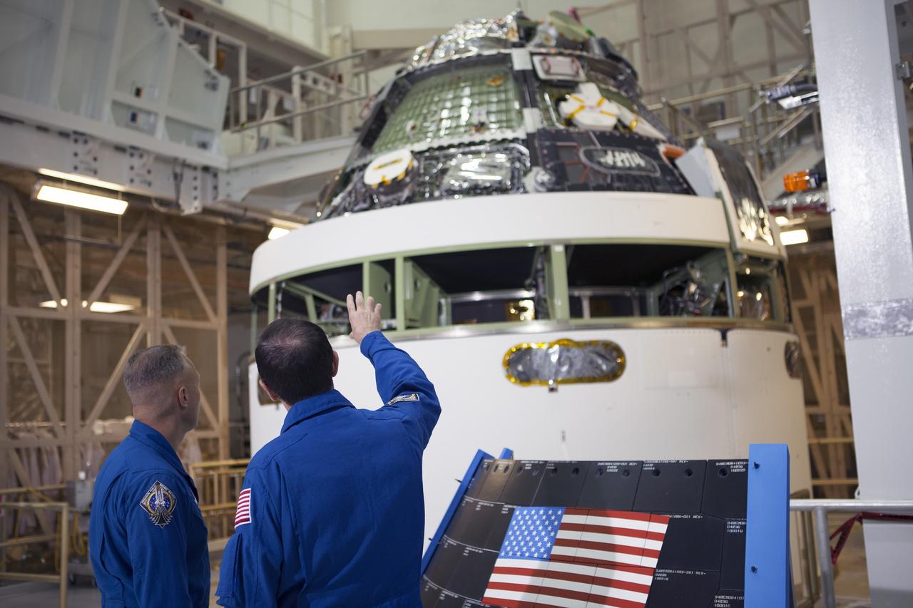 CAPE CANAVERAL, Fla. – NASA astronauts Doug Hurley, left, and Rex Walheim look at the Orion crew module stacked on top of the service module in the Final Assembly and System Test cell inside the Operations and Checkout Building high bay at NASA's Kennedy Space Center in Florida. An event was held to mark the T-6 months and counting to the launch of Orion on Exploration Flight Test-1, or EFT-1. The flight test will provide engineers with data about the heat shield's ability to protect Orion and its future crews from the 4,000-degree heat of reentry and an ocean splashdown following the spacecraft’s 20,000-mph reentry from space. Data gathered during the flight will inform decisions about design improvements on the heat shield and other Orion systems, and authenticate existing computer models and new approaches to space systems design and development. This process is critical to reducing overall risks and costs of future Orion missions. Orion is the exploration spacecraft designed to carry astronauts to destinations not yet explored by humans, including an asteroid and Mars. It will have emergency abort capability, sustain the crew during space travel and provide safe re-entry from deep space return velocities. The first unpiloted test flight of the Orion is scheduled to launch later this year atop a Delta IV rocket from Cape Canaveral Air Force Station in Florida to an altitude of 3,600 miles above the Earth's surface. The two-orbit, four-hour flight test will help engineers evaluate the systems critical to crew safety including the heat shield, parachute system and launch abort system. For more information, visit http://www.nasa.gov/orion. Photo credit: NASA/Kim Shiflett