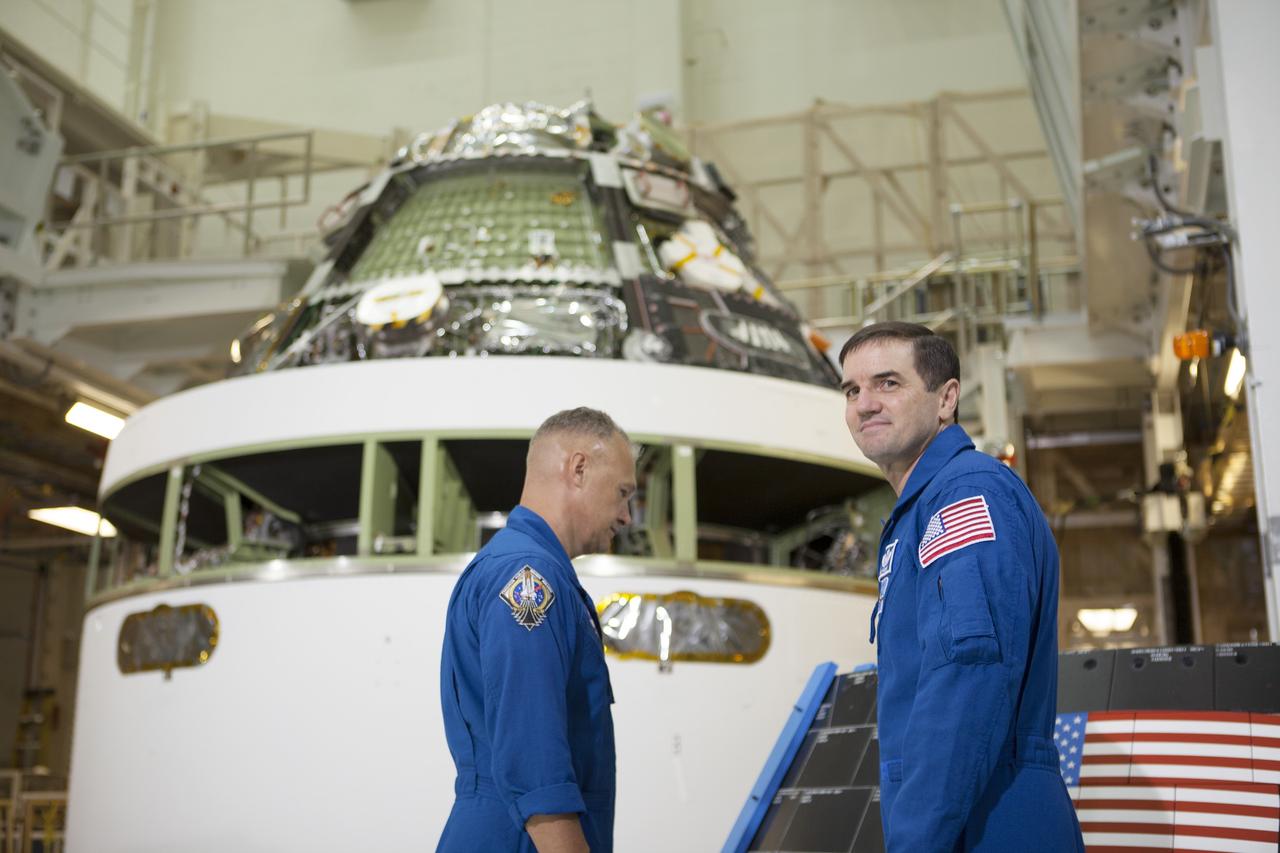 CAPE CANAVERAL, Fla. – NASA astronauts Doug Hurley, left, and Rex Walheim look at the Orion crew module stacked on top of the service module in the Final Assembly and System Test cell inside the Operations and Checkout Building high bay at NASA's Kennedy Space Center in Florida. An event was held to mark the T-6 months and counting to the launch of Orion on Exploration Flight Test-1, or EFT-1. The flight test will provide engineers with data about the heat shield's ability to protect Orion and its future crews from the 4,000-degree heat of reentry and an ocean splashdown following the spacecraft’s 20,000-mph reentry from space. Data gathered during the flight will inform decisions about design improvements on the heat shield and other Orion systems, and authenticate existing computer models and new approaches to space systems design and development. This process is critical to reducing overall risks and costs of future Orion missions. Orion is the exploration spacecraft designed to carry astronauts to destinations not yet explored by humans, including an asteroid and Mars. It will have emergency abort capability, sustain the crew during space travel and provide safe re-entry from deep space return velocities. The first unpiloted test flight of the Orion is scheduled to launch later this year atop a Delta IV rocket from Cape Canaveral Air Force Station in Florida to an altitude of 3,600 miles above the Earth's surface. The two-orbit, four-hour flight test will help engineers evaluate the systems critical to crew safety including the heat shield, parachute system and launch abort system. For more information, visit http://www.nasa.gov/orion. Photo credit: NASA/Kim Shiflett