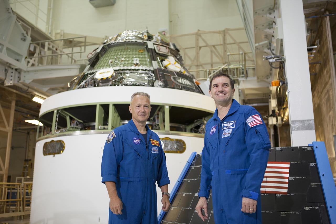 CAPE CANAVERAL, Fla. – NASA astronauts Doug Hurley, left, and Rex Walheim helped mark the T-6 months and counting to the launch of Orion on Exploration Flight Test-1, or EFT-1, during a visit to the Operations and Checkout Building high bay at NASA's Kennedy Space Center in Florida. Behind them, the Orion crew module has been stacked on top of the service module in the Final Assembly and System Test cell. EFT-1 will provide engineers with data about the heat shield's ability to protect Orion and its future crews from the 4,000-degree heat of reentry and an ocean splashdown following the spacecraft’s 20,000-mph reentry from space. Data gathered during the flight will inform decisions about design improvements on the heat shield and other Orion systems, and authenticate existing computer models and new approaches to space systems design and development. This process is critical to reducing overall risks and costs of future Orion missions. Orion is the exploration spacecraft designed to carry astronauts to destinations not yet explored by humans, including an asteroid and Mars. It will have emergency abort capability, sustain the crew during space travel and provide safe re-entry from deep space return velocities. The first unpiloted test flight of the Orion is scheduled to launch later this year atop a Delta IV rocket from Cape Canaveral Air Force Station in Florida to an altitude of 3,600 miles above the Earth's surface. The two-orbit, four-hour flight test will help engineers evaluate the systems critical to crew safety including the heat shield, parachute system and launch abort system. For more information, visit http://www.nasa.gov/orion. Photo credit: NASA/Kim Shiflett