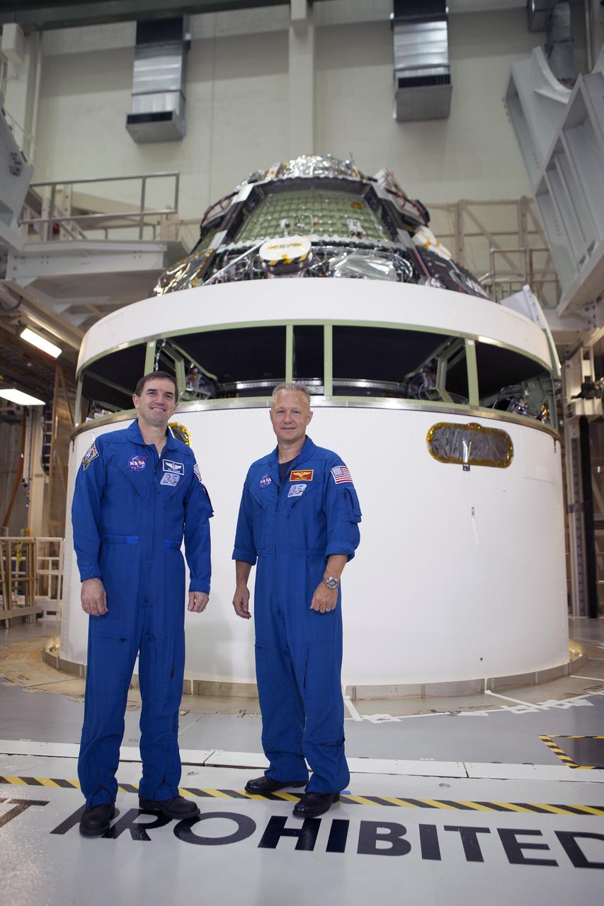 CAPE CANAVERAL, Fla. – NASA astronauts Rex Walheim, left, and Doug Hurley helped mark the T-6 months and counting to the launch of Orion on Exploration Flight Test-1, or EFT-1, during a visit to the Operations and Checkout Building high bay at NASA's Kennedy Space Center in Florida. Behind them the Orion crew module has been stacked on top of the service module in the Final Assembly and System Test cell. EFT-1 will provide engineers with data about the heat shield's ability to protect Orion and its future crews from the 4,000-degree heat of reentry and an ocean splashdown following the spacecraft’s 20,000-mph reentry from space. Data gathered during the flight will inform decisions about design improvements on the heat shield and other Orion systems, and authenticate existing computer models and new approaches to space systems design and development. This process is critical to reducing overall risks and costs of future Orion missions. Orion is the exploration spacecraft designed to carry astronauts to destinations not yet explored by humans, including an asteroid and Mars. It will have emergency abort capability, sustain the crew during space travel and provide safe re-entry from deep space return velocities. The first unpiloted test flight of the Orion is scheduled to launch later this year atop a Delta IV rocket from Cape Canaveral Air Force Station in Florida to an altitude of 3,600 miles above the Earth's surface. The two-orbit, four-hour flight test will help engineers evaluate the systems critical to crew safety including the heat shield, parachute system and launch abort system. For more information, visit http://www.nasa.gov/orion. Photo credit: NASA/Kim Shiflett