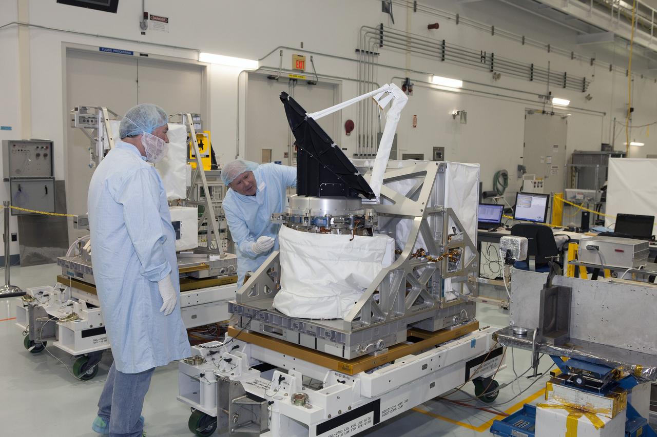 CAPE CANAVERAL, Fla. – Personnel from NASA's Jet Propulsion Laboratory JPL in California oversee testing of the rotating radar antenna on NASA's International Space Station-RapidScat in the Space Station Processing Facility at NASA's Kennedy Space Center in Florida. From left are JPL flight technician Kieran McKay and RapidScat project manager John Wirth. Built at JPL, the radar scatterometer is the first scientific Earth-observing instrument designed to operate from the exterior of the space station. It will measure Earth's ocean surface wind speed and direction, providing data to be used in weather and marine forecasting. ISS-RapidScat will be delivered to the station on the SpaceX-4 commercial cargo resupply flight targeted for August 2014. For more information, visit http://www.jpl.nasa.gov/missions/iss-rapidscat. Photo credit: NASA/Daniel Casper