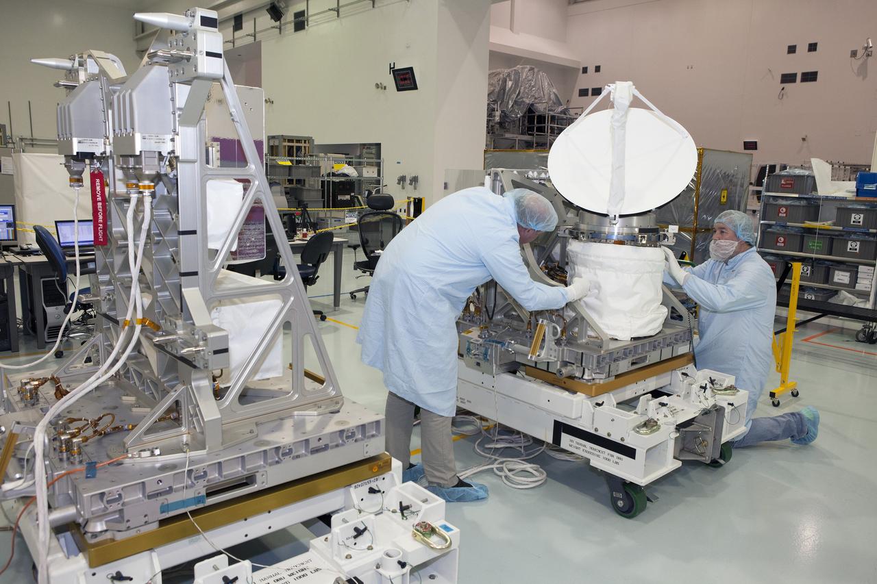 CAPE CANAVERAL, Fla. – Personnel from NASA's Jet Propulsion Laboratory JPL in California secure the protective cover around NASA's International Space Station-RapidScat during testing of its rotating radar antenna and its flight computer and airborne support equipment, at left, in the Space Station Processing Facility at NASA's Kennedy Space Center in Florida. From left are RapidScat project manager John Wirth and JPL flight technician Kieran McKay. Built at JPL, the radar scatterometer is the first scientific Earth-observing instrument designed to operate from the exterior of the space station. It will measure Earth's ocean surface wind speed and direction, providing data to be used in weather and marine forecasting. ISS-RapidScat will be delivered to the station on the SpaceX-4 commercial cargo resupply flight targeted for August 2014. For more information, visit http://www.jpl.nasa.gov/missions/iss-rapidscat. Photo credit: NASA/Daniel Casper