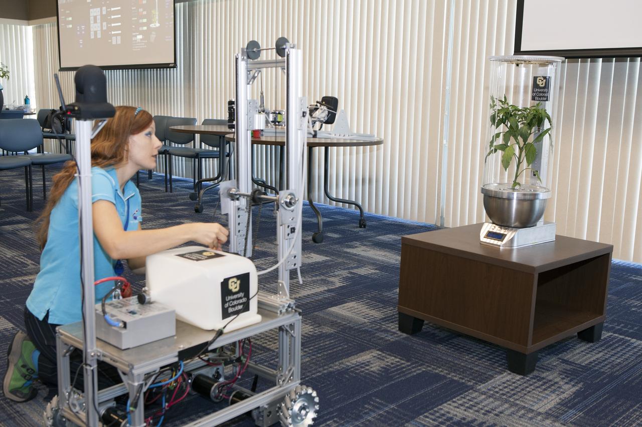 CAPE CANAVERAL, Fla. -- At the Kennedy Space Center in Florida, Heather Hava, who is working on a doctorate in aerospace engineering sciences at the University of Colorado Boulder, makes adjustments on a Remotely Operated Gardening Rover, or ROGR, which could tend to plants grown in one of the SmartPots, or SPOTS seen on the right. The system is being developed by the graduate students participating in the eXploration HABitat X-Hab Academic Innovation Challenge.      X-Hab Academic Innovation Challenge is a university-level activity designed to engage and retain students in science, technology, engineering and math, or STEM, disciplines. NASA will directly benefit from the effort by sponsoring the development of innovative habitat concepts from universities which may result in innovative ideas and solutions that could be applied to exploration habitats. For more: http://www.nasa.gov/exploration/technology/deep_space_habitat/xhab/ Photo credit: NASA/Daniel Casper