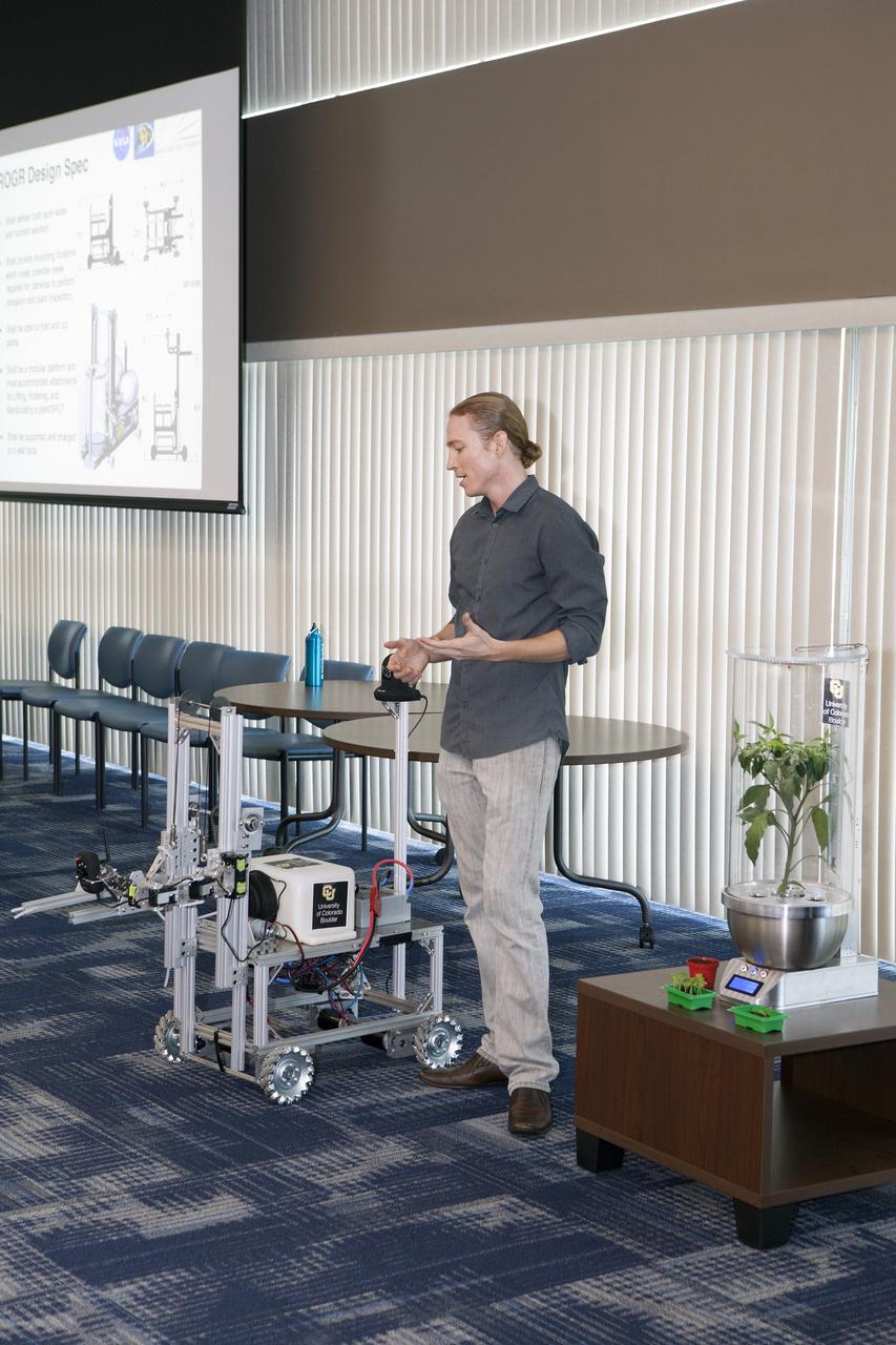 CAPE CANAVERAL, Fla. -- At the Kennedy Space Center in Florida, Daniel Zukowski, a University of Colorado Boulder graduate student, describes a Remotely Operated Gardening Rover, or ROGR, which could tend to plants grown in one of the SmartPots, or SPOTS, seen on the right. The system is being developed by the graduate students participating in the eXploration HABitation X-Hab Academic Innovation Challenge.      X-Hab Academic Innovation Challenge is a university-level activity designed to engage and retain students in science, technology, engineering and math, or STEM, disciplines. NASA will directly benefit from the effort by sponsoring the development of innovative habitat concepts from universities which may result in innovative ideas and solutions that could be applied to exploration habitats. For more: http://www.nasa.gov/exploration/technology/deep_space_habitat/xhab/ Photo credit: NASA/Daniel Casper